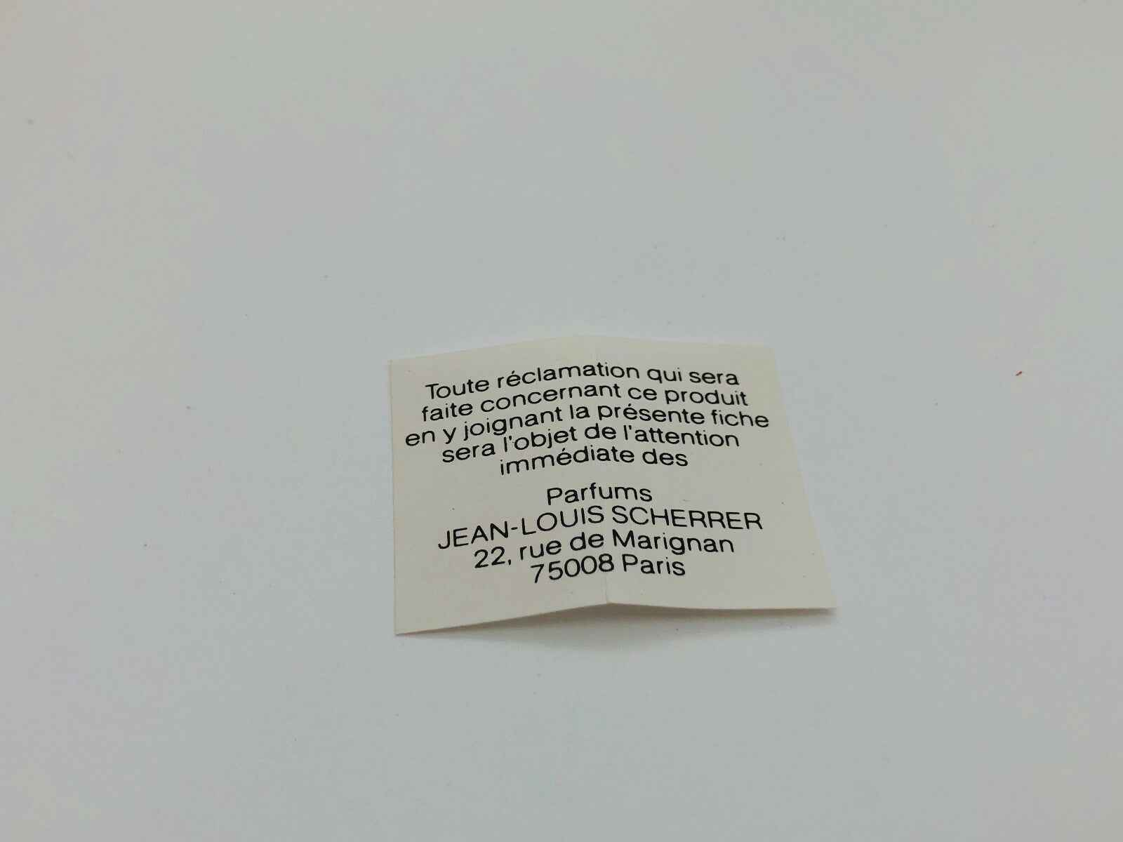 Etichetta del profumo Jean Louis Scherrer con informazioni di contatto e indirizzo a Parigi