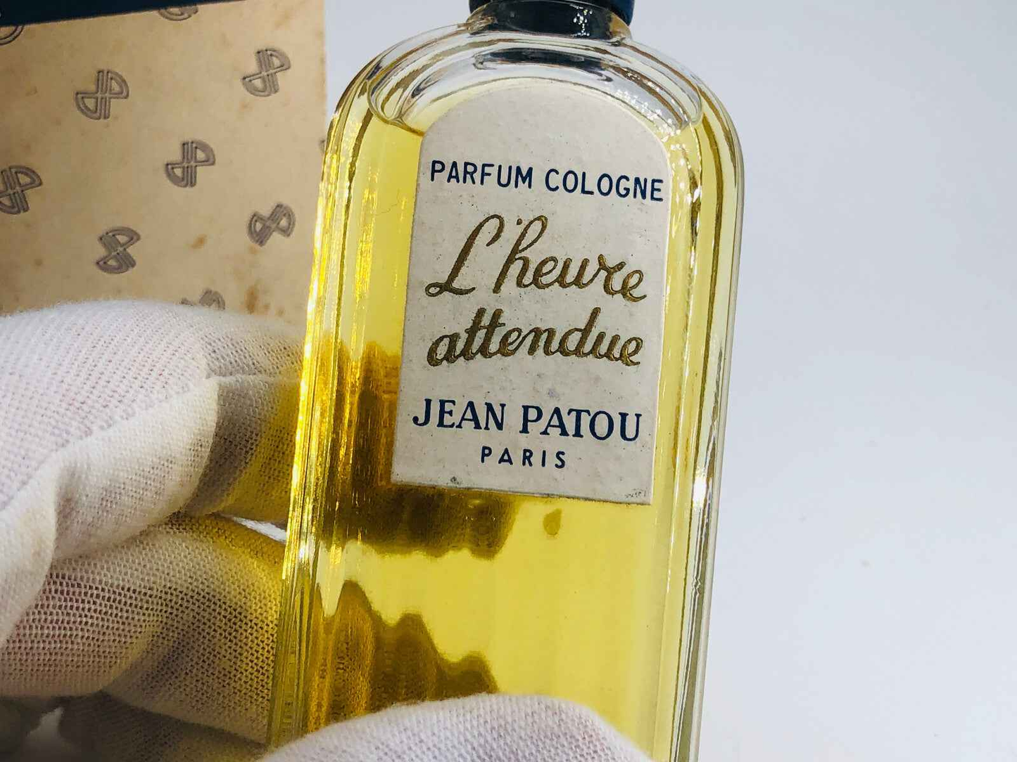 Flacone di profumo Jean Patou L Heure Attendue con etichetta elegante e liquido dorato