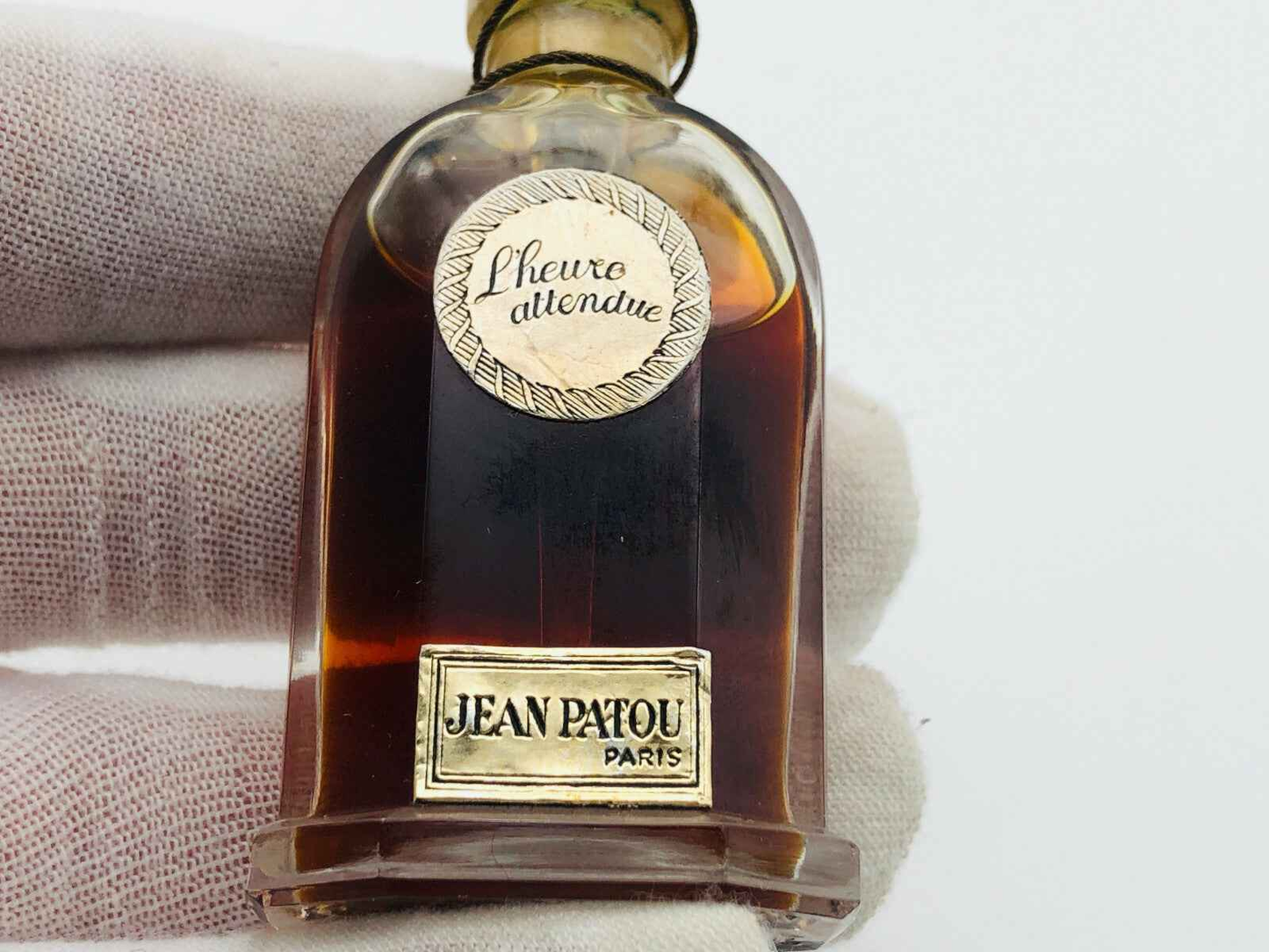 Bottiglia di profumo Jean Patou Vintage con etichetta dorata e design classico