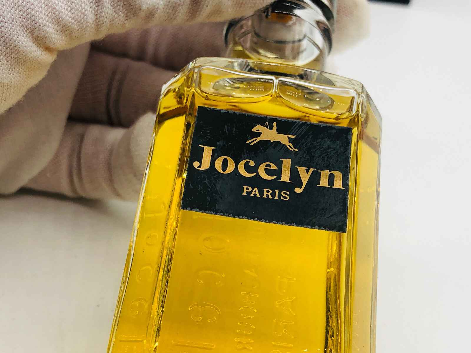 Bottiglia di Profumo Jocelyn Pour Homme con etichetta elegante in colori dorati e neri