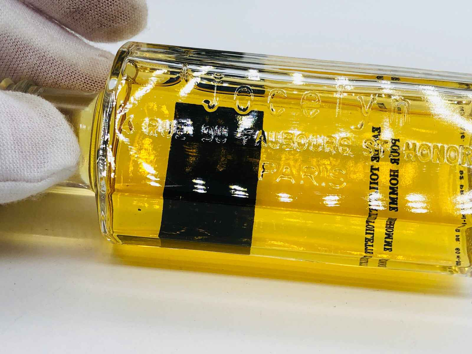 Flacone di profumo Jocelyn Pour Homme con liquido giallo e etichetta elegante