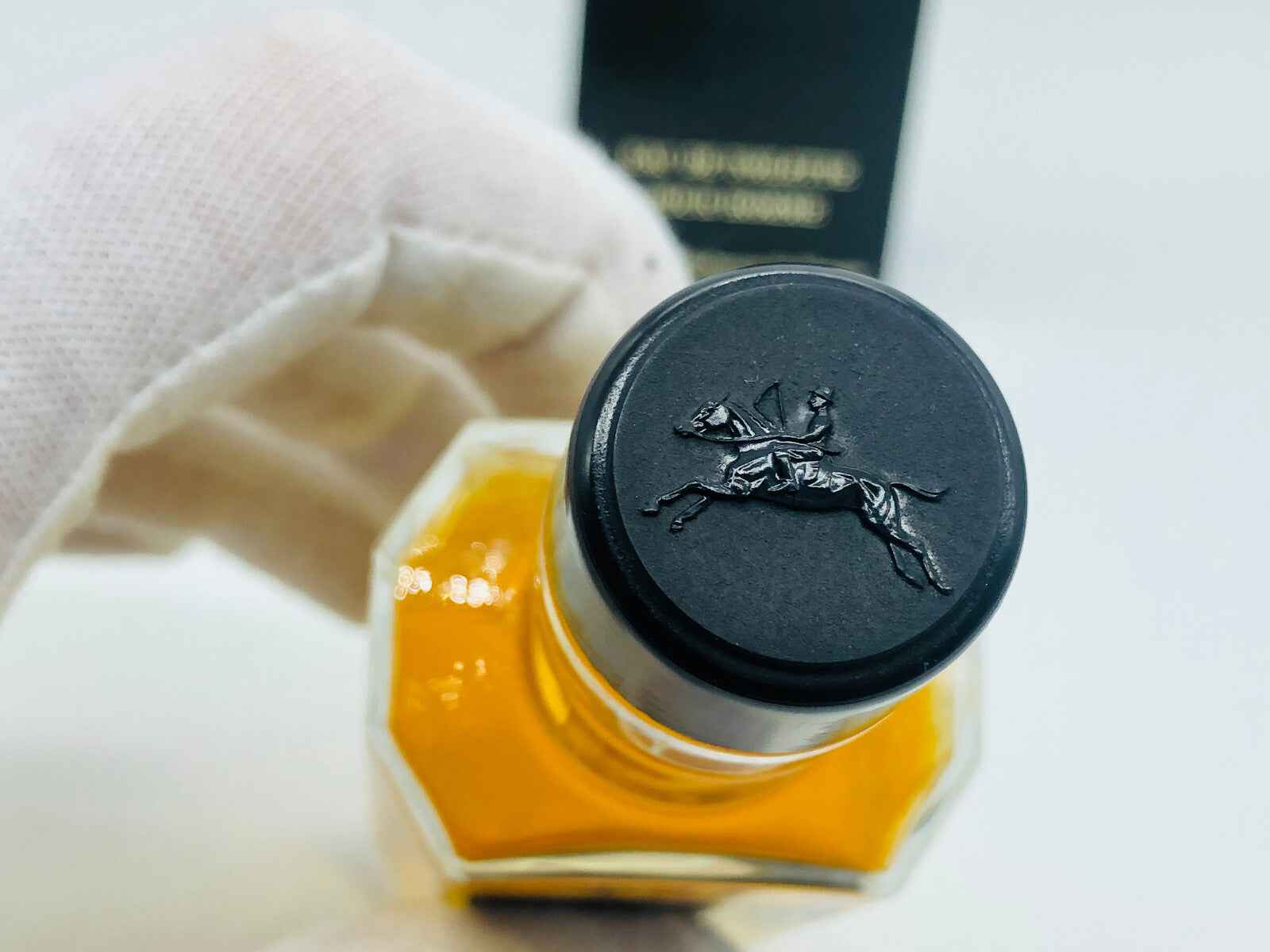 Tappo di profumo Jocelyn Pour Homme con logo elegante in rilievo su sfondo dorato