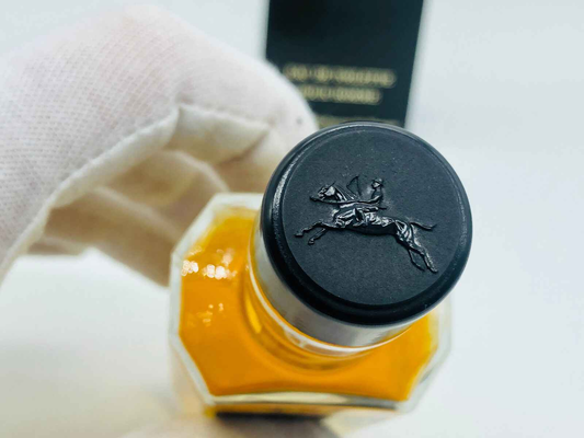 Tappo di profumo Jocelyn Pour Homme con logo elegante in rilievo su sfondo dorato