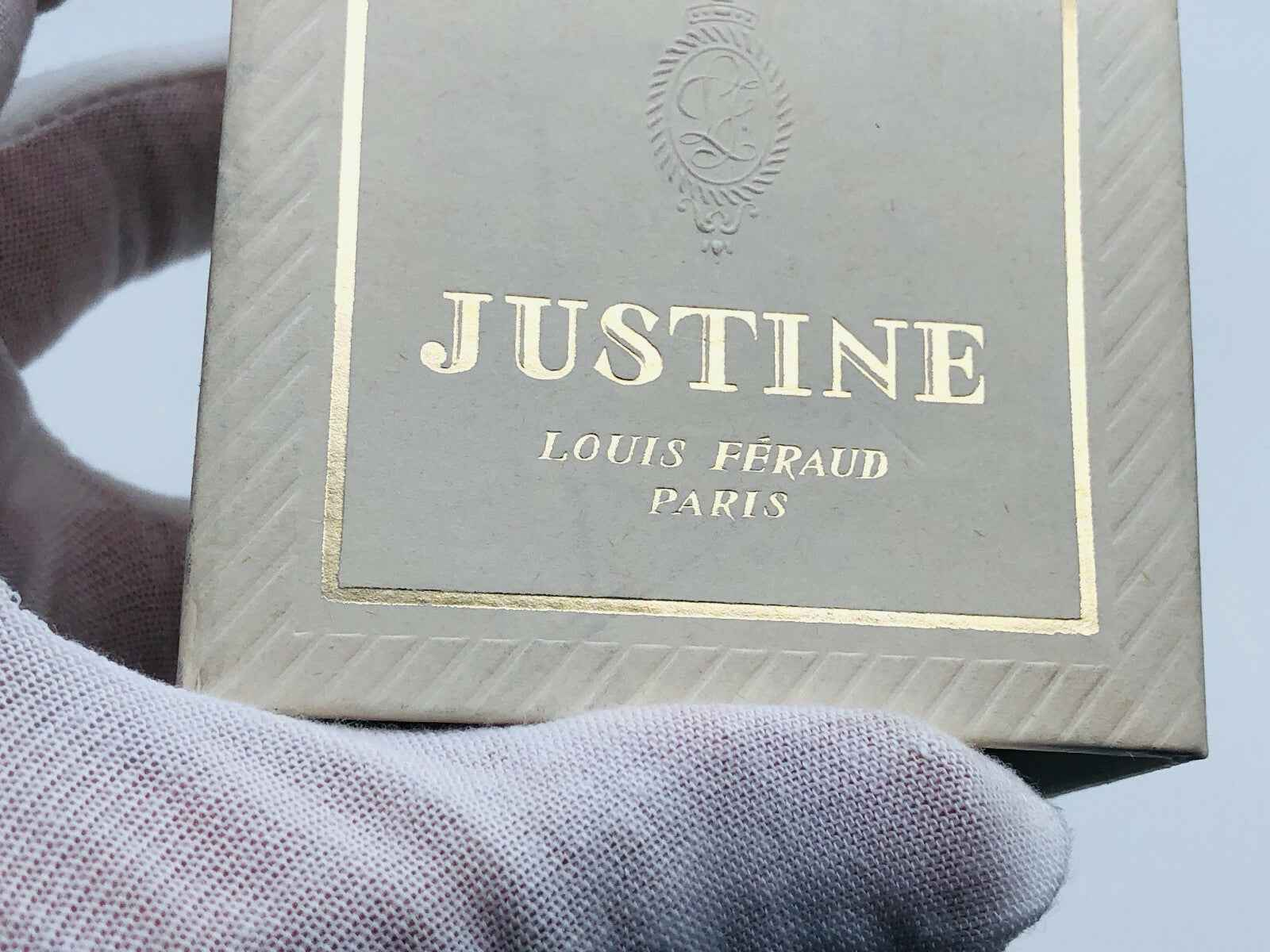 Scatola di profumo Justine Louis Feraud con dettagli in oro e logo a rilievo