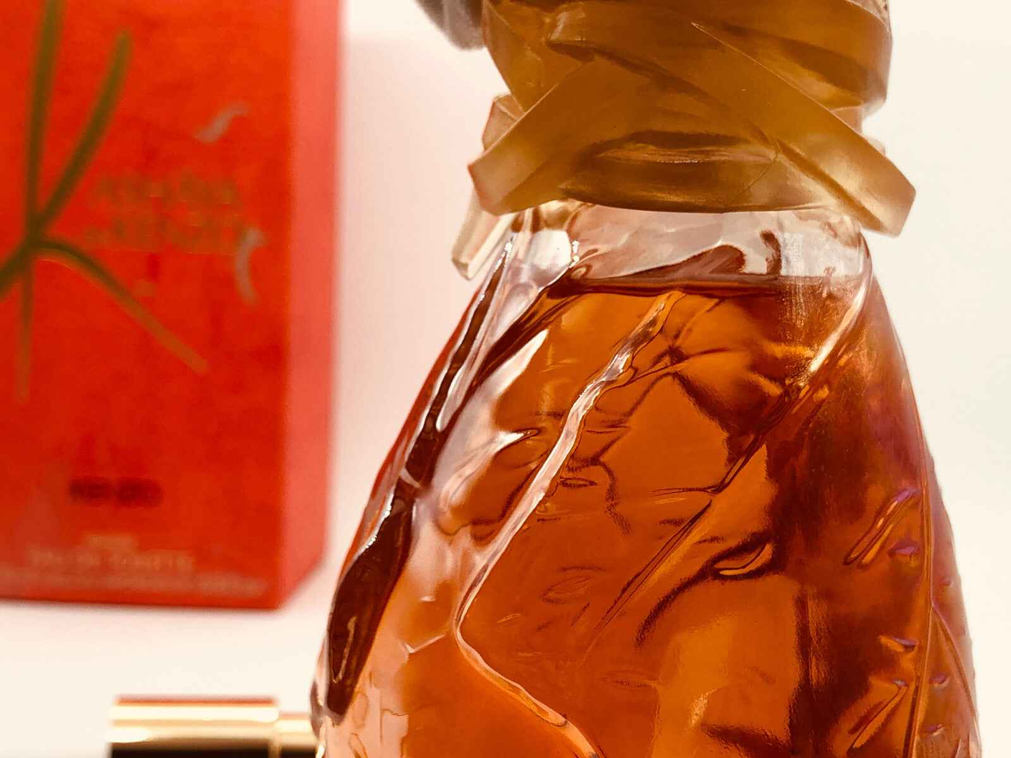 Flacone di profumo Kenzo Kashaya con design unico e confezione rossa elegante sullo sfondo