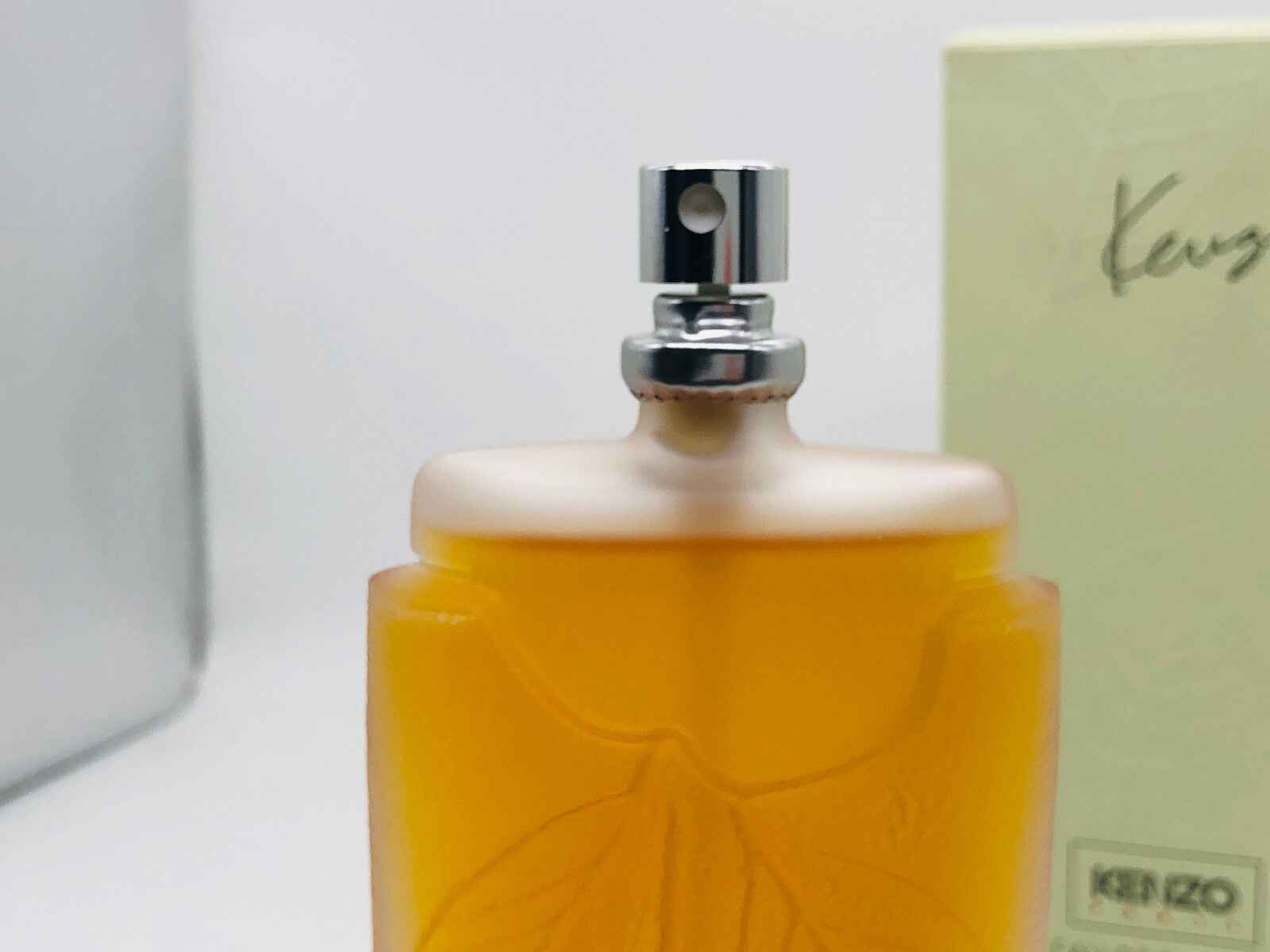 Flacone di KENZO Profumo Vintage con tappo argentato e aroma floreale, elegante e raffinato