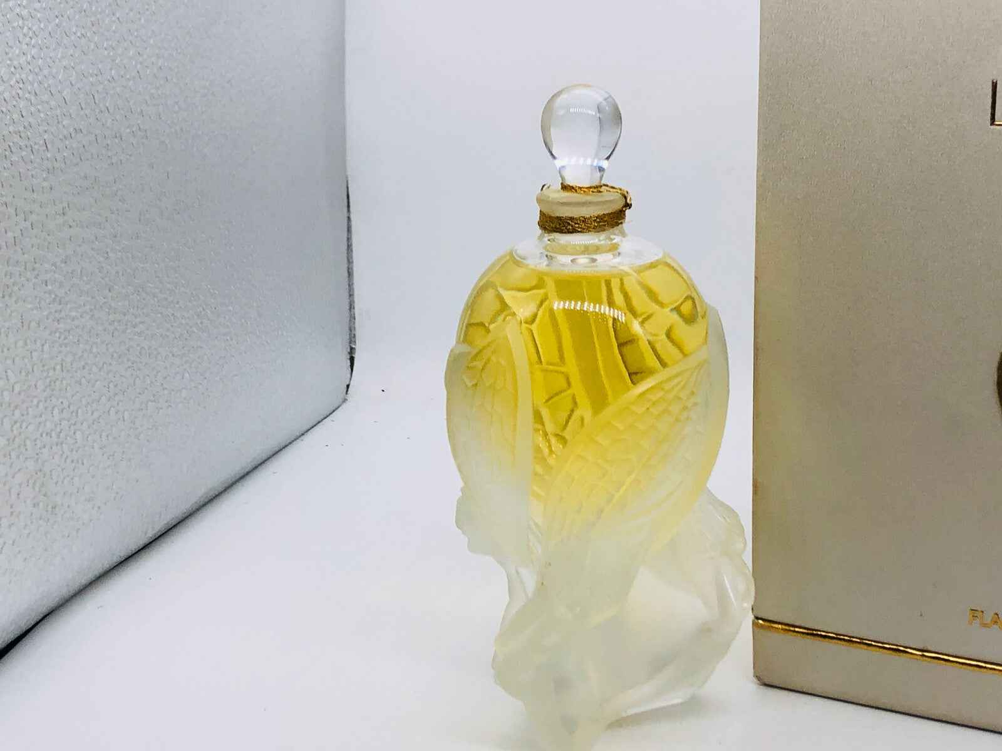 Bottiglia di profumo Lalique Les Elfes con tappo sferico e design elegante, contenente profumo dorato