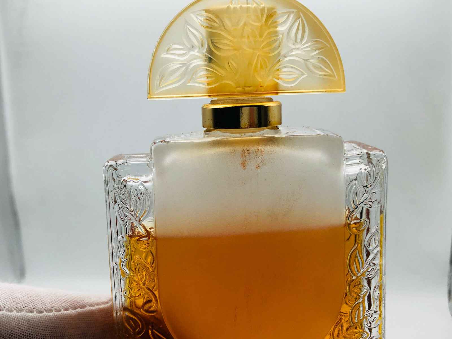 Bottiglia di profumo Lalique Vintage con design elegante e liquido dorato all'interno