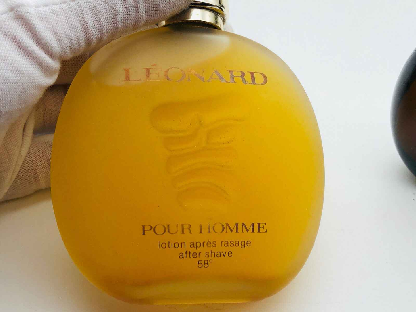 Flacone di profumo Leonard Pour Homme in vetro giallo con etichetta chiara e design elegante