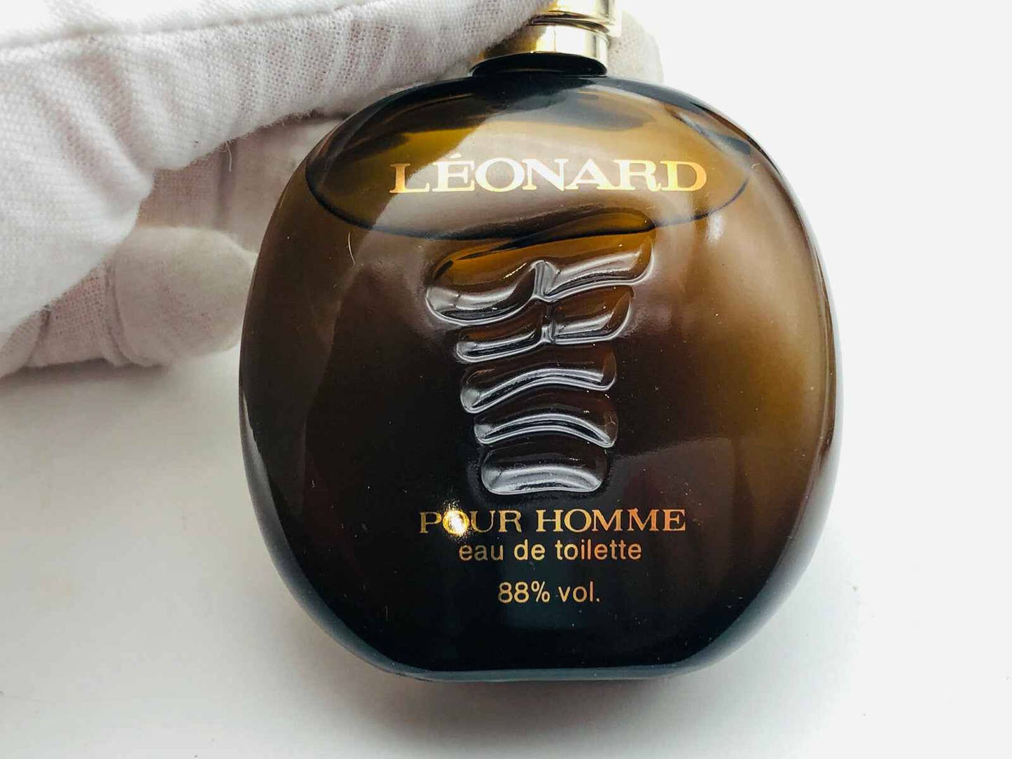 Bottiglia di profumo Leonard Pour Homme in vetro marrone con etichetta dorata ed elegante design