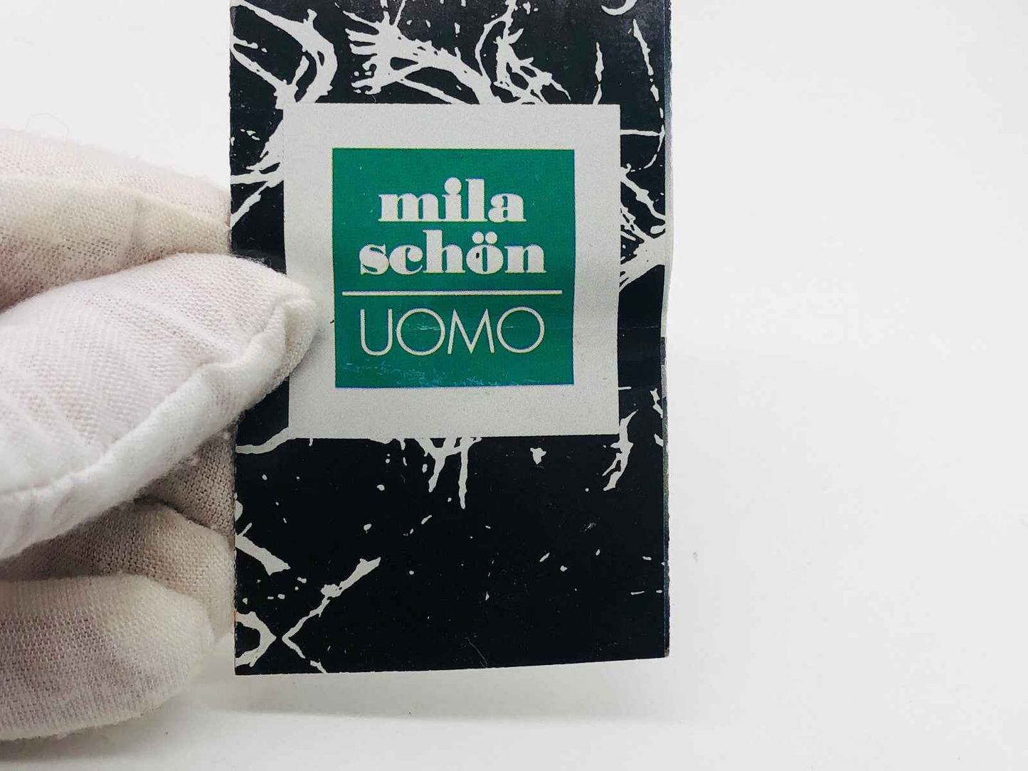 Etichetta vintage di moda Mila Schon Uomo Vintage su sfondo nero con design moderno