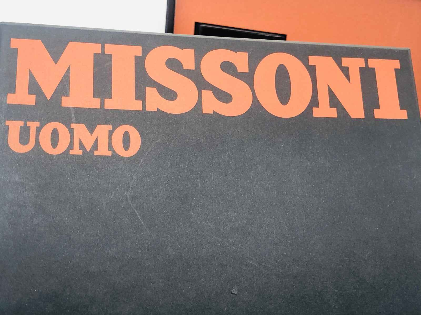 Confezione del Profumo Missoni Uomo Vintage con logo distintivo in arancione su sfondo nero