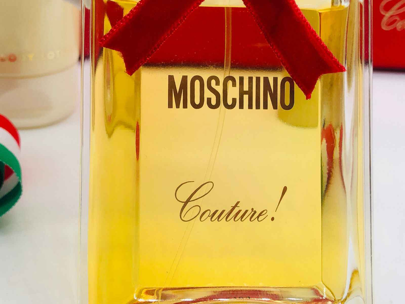 Flacone di profumo Moschino Couture Vintage con nastro rosso e design elegante per un tocco di classe
