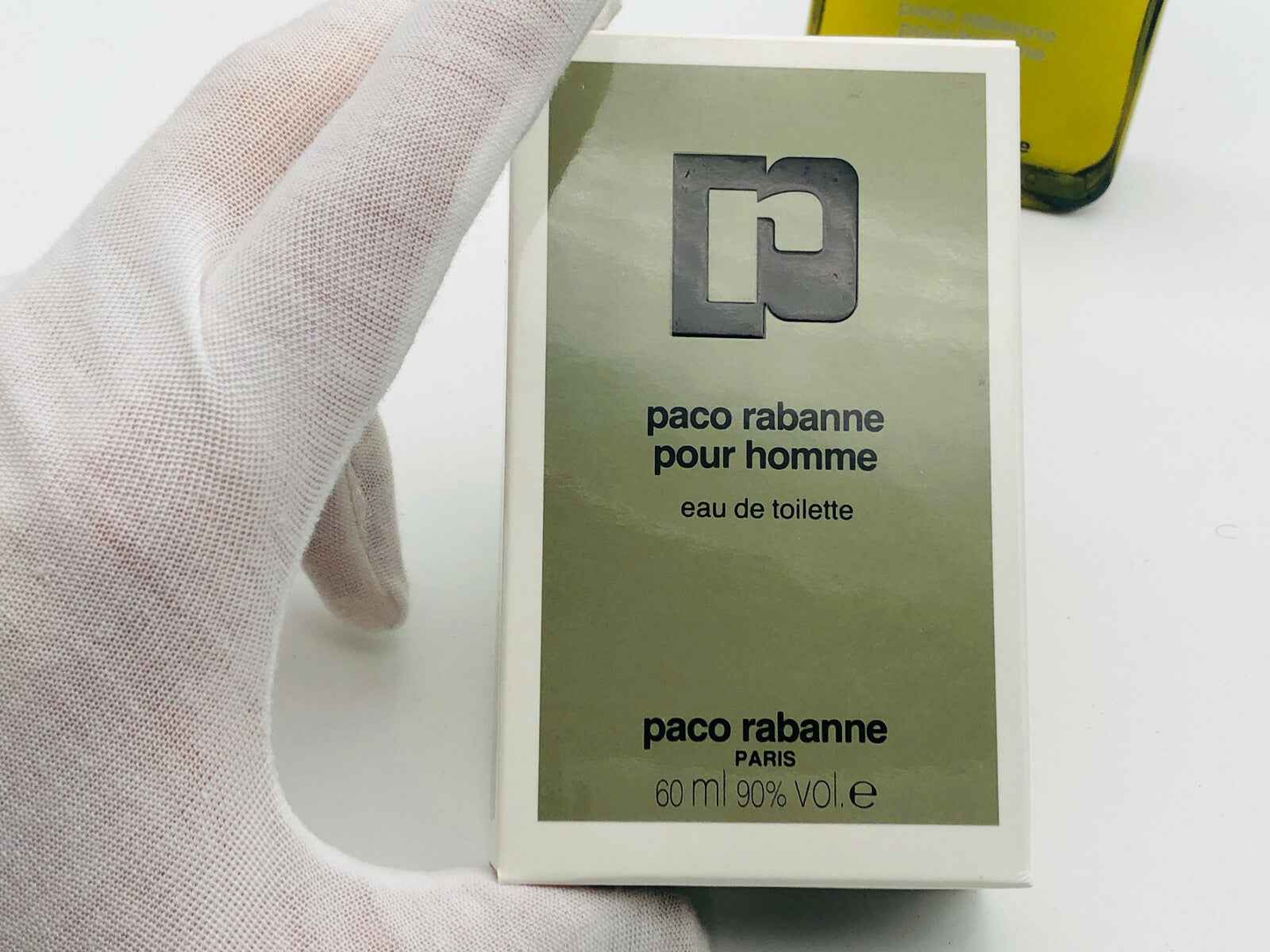 Scatola di profumo Paco Rabanne Vintage pour homme 60 ml in una mano con guanto bianco