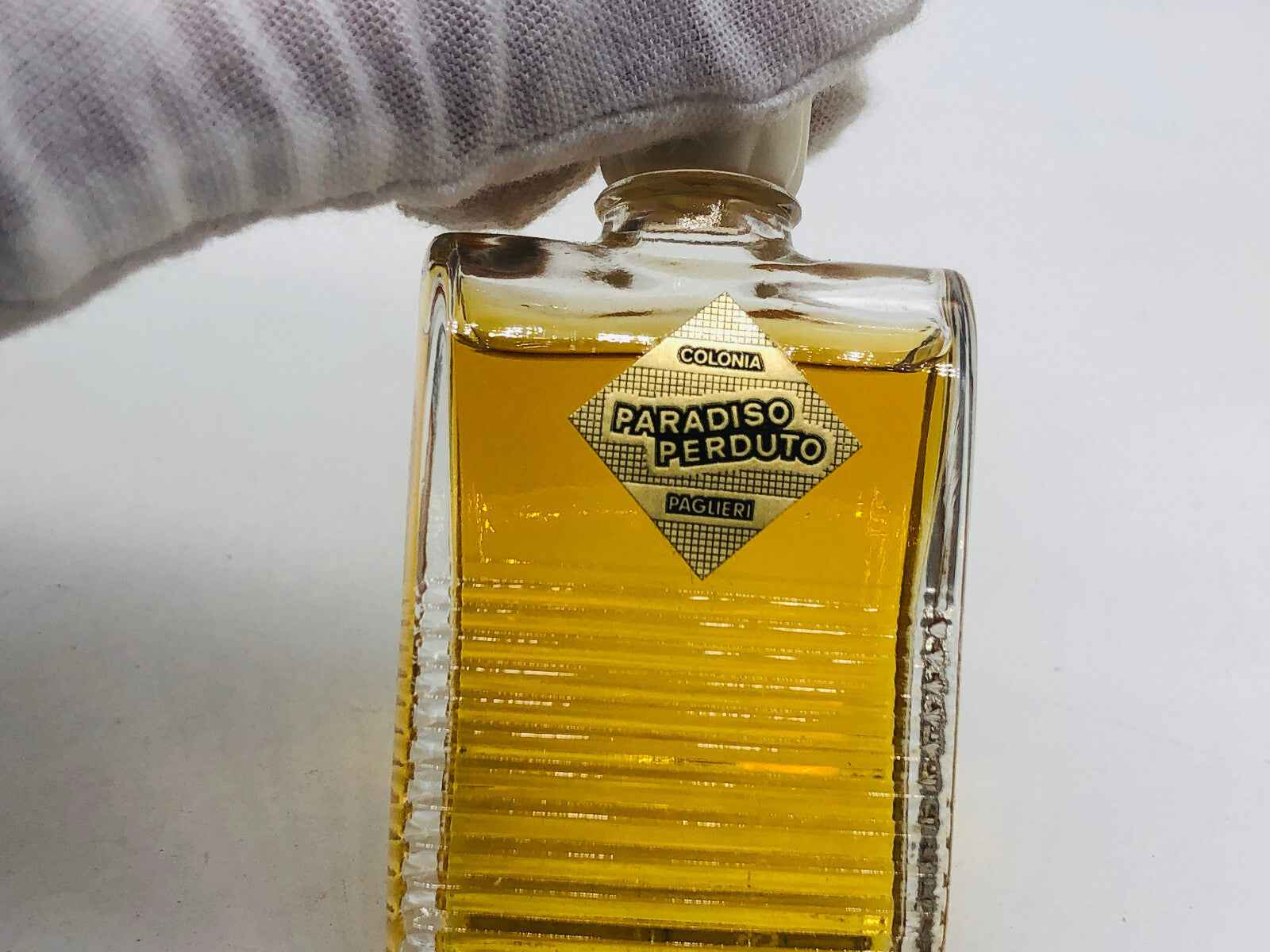 Bottiglia di profumo Paglieri Paradiso Perduto con etichetta vintage e liquido giallo dorato