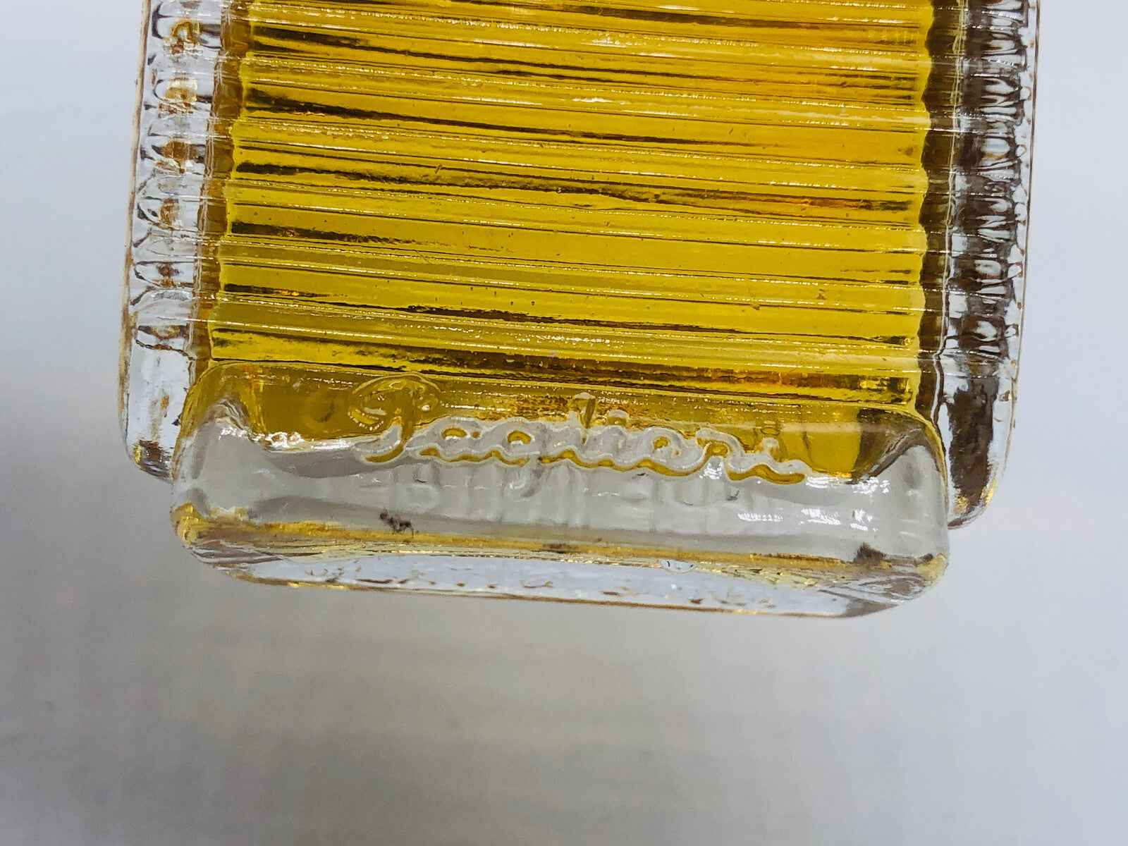 Bottiglia di profumo Paglieri Paradiso Perduto con design elegante e liquido dorato