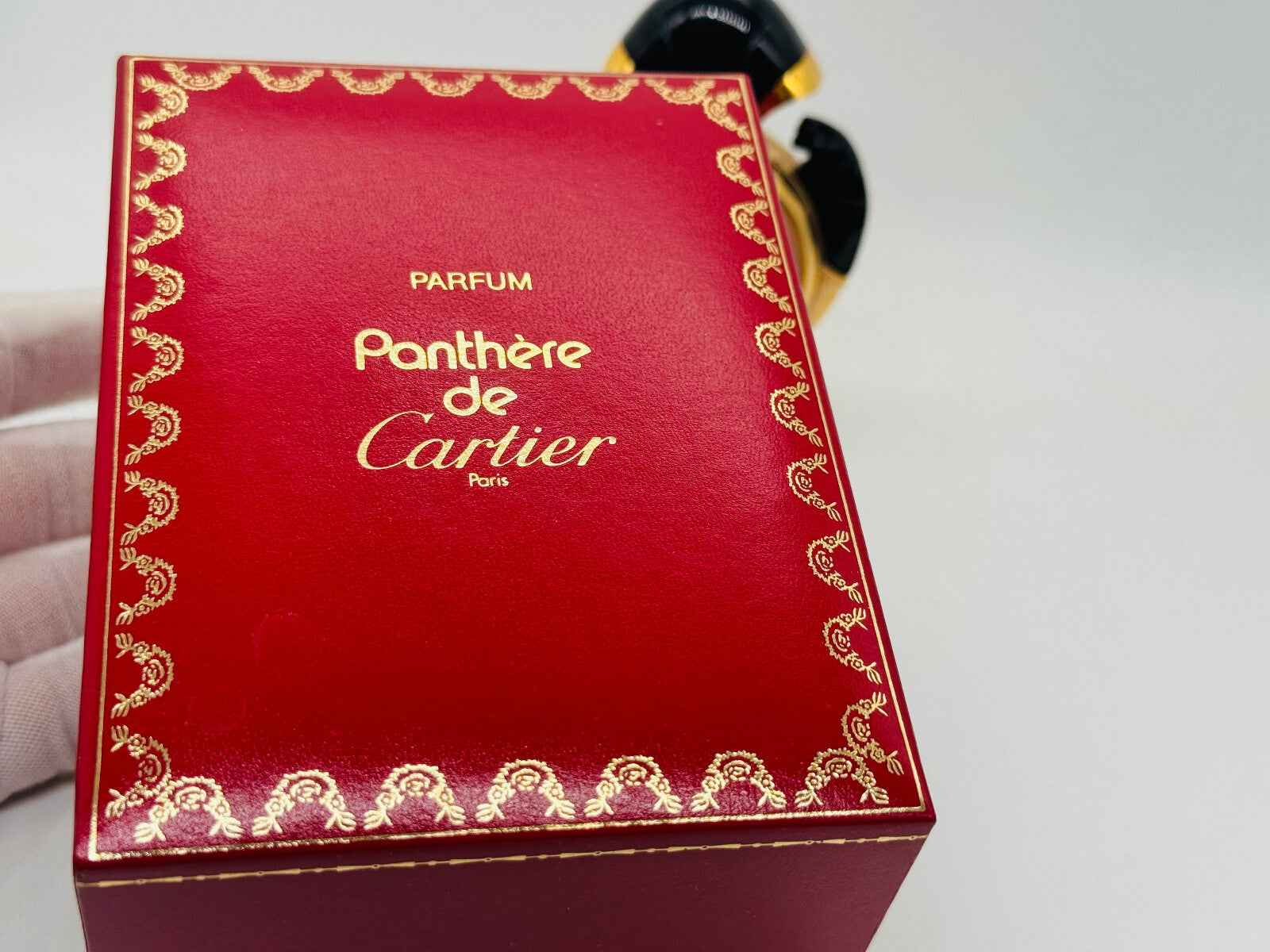 Scatola rossa vintage del profumo Panthère Cartier con decorazioni dorate e logo elegante