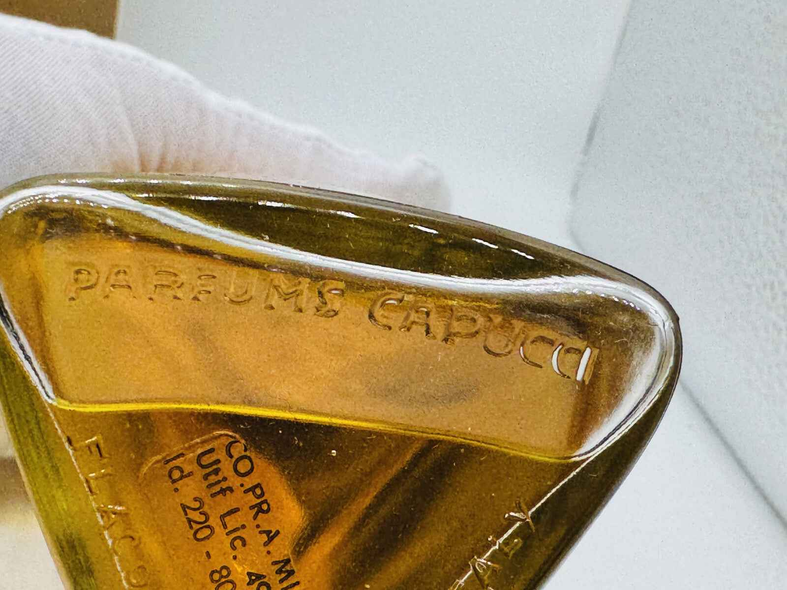 Flacone di profumo Parce Que Capucci con design elegante e liquido dorato