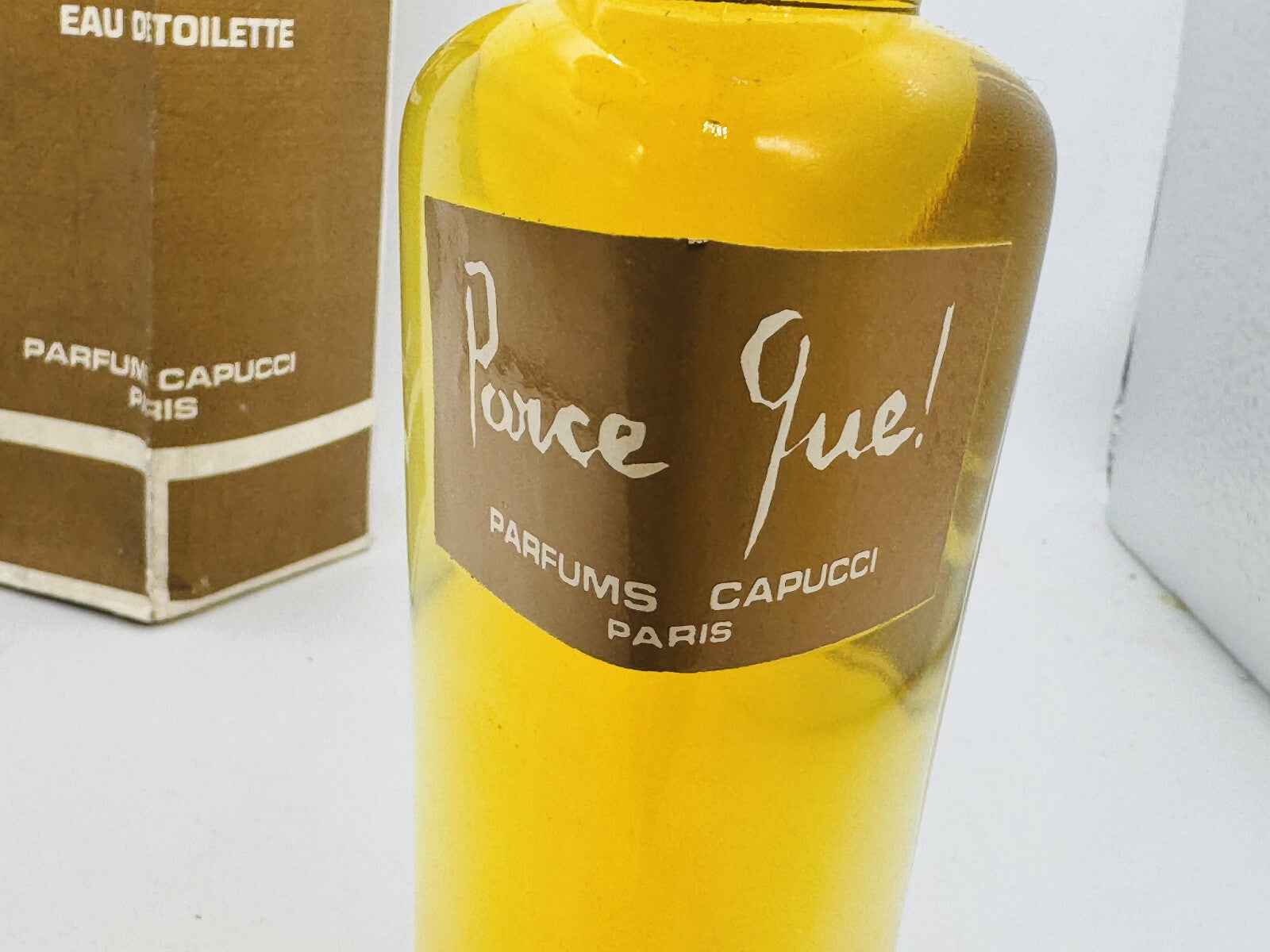 Flacone di profumo Parce Que Capucci con etichetta marrone e design semplice