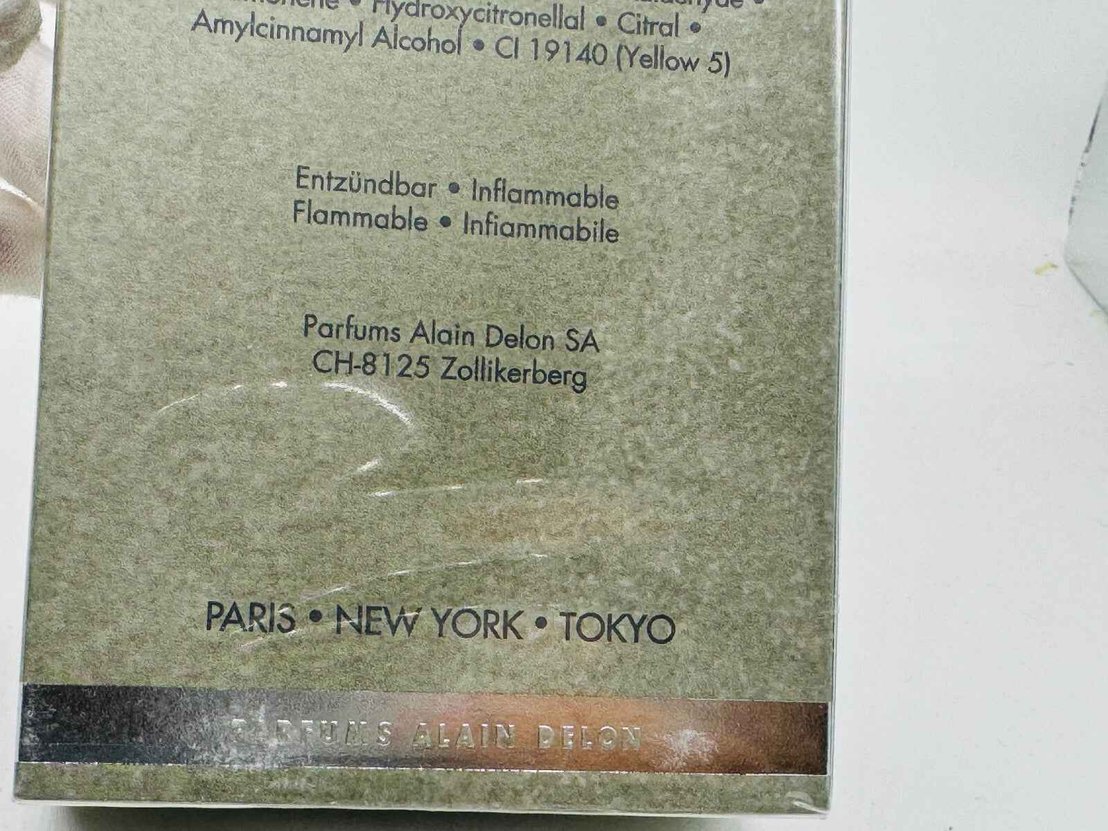 Scatola del profumo Alain Delon Samourai, elegante design con dettagli di produzione e città.