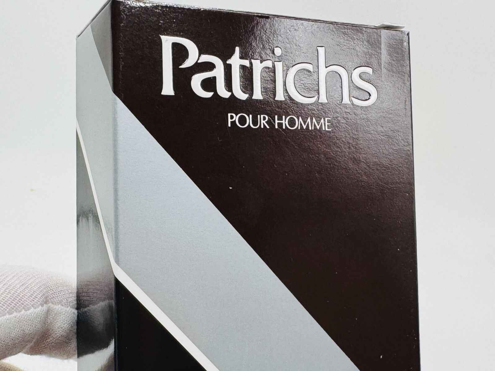 Scatola della fragranza Patrichs Pour Homme Vintage con design elegante e moderno in nero e argento