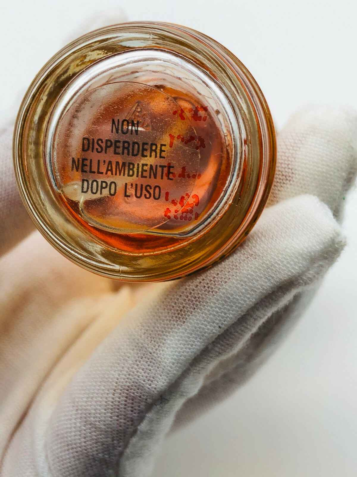 Flacone di Profumo Perlier Pour Elise con etichetta per la sicurezza ambientale, tenuto in mano con guanto bianco