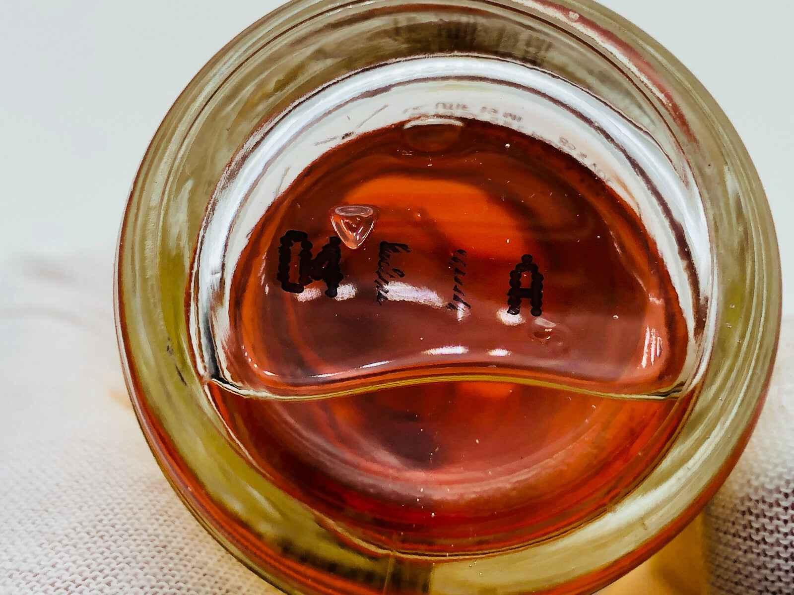 Bottiglia di profumo Pour Elise Perlier con liquido ambrato e etichetta visibile sul fondo