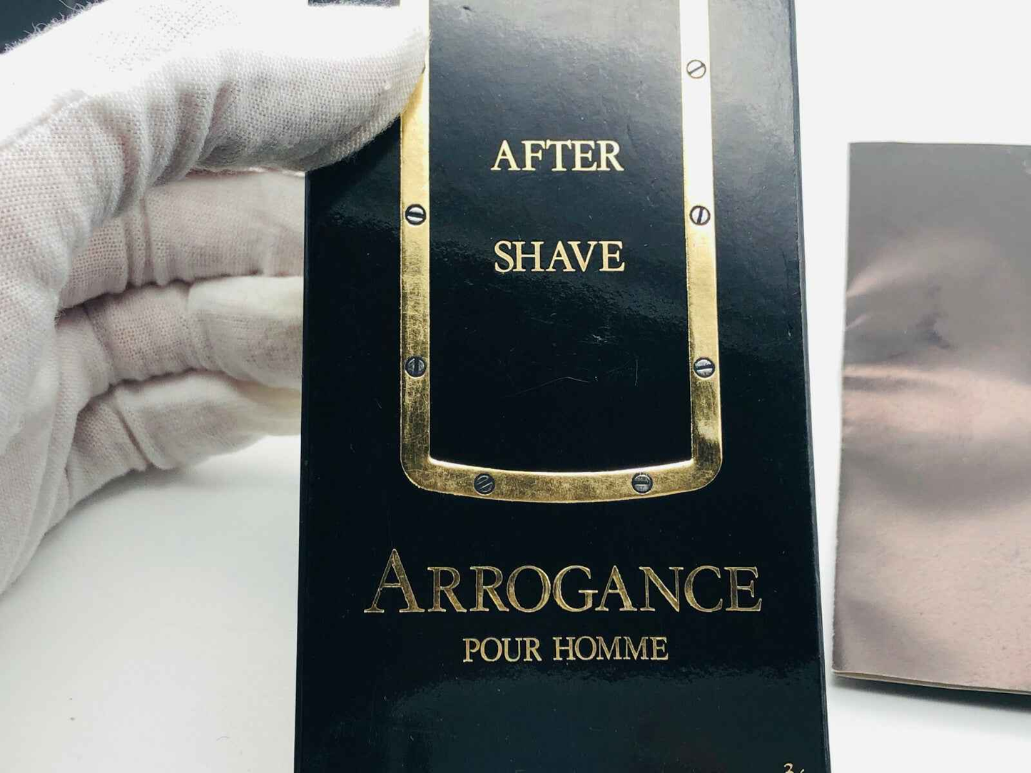 Confezione di Arrogance Pour Homme after shave in confezione nera con dettagli dorati