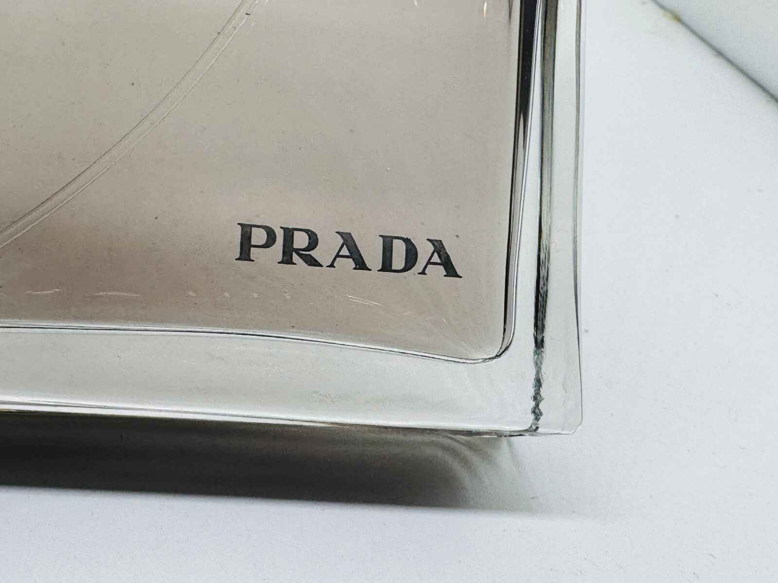 Dettaglio della confezione di Profumo Prada Amber Pour Homme con logo PRADA visibile