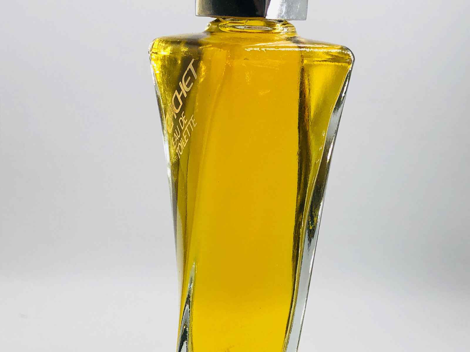 Flacone di Profumo Prince Matchabelli Cachet in vetro trasparente con liquido giallo dorato.