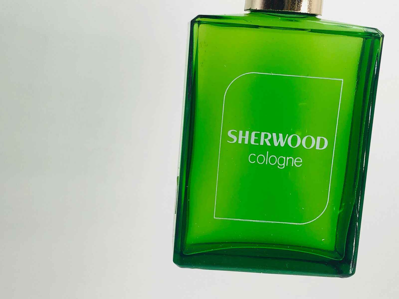 Flacone di profumo verde Procarg Sherwood con etichetta bianca e tappo dorato