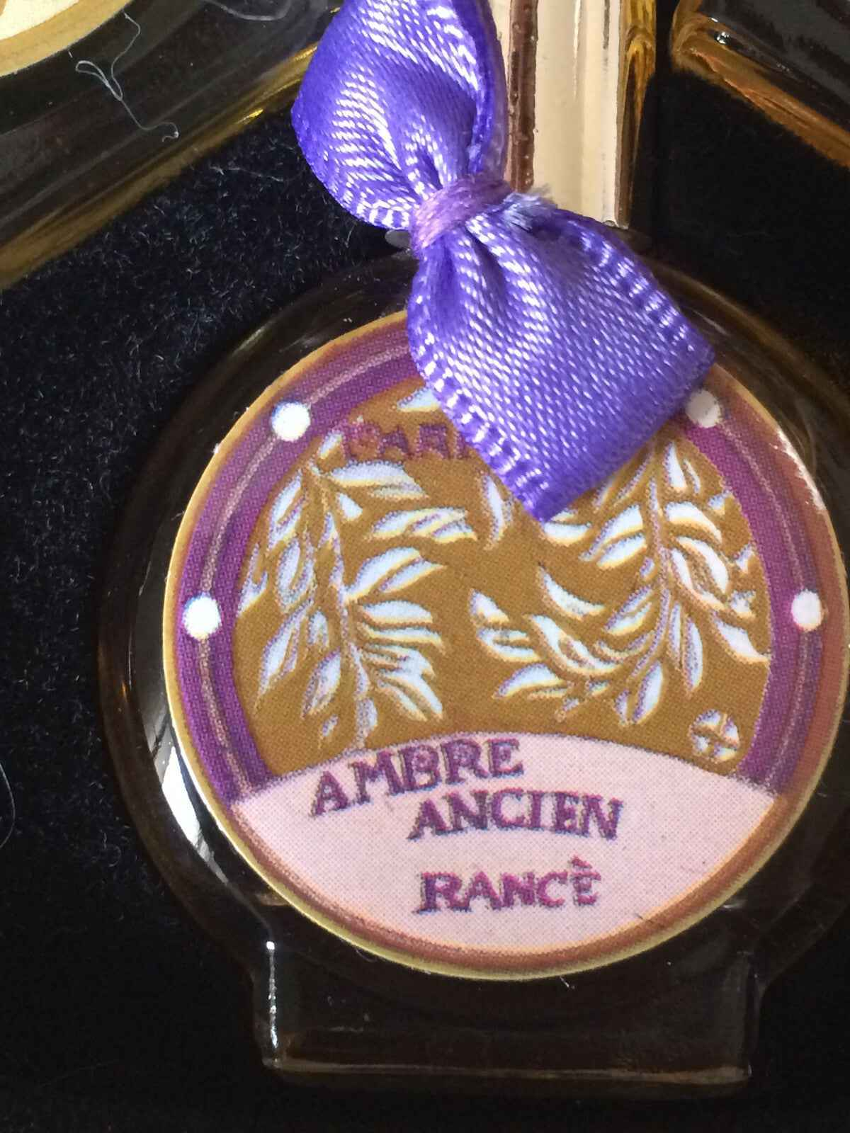 Flacone di profumo Rance Ambre Ancien con etichetta decorativa e nastro viola