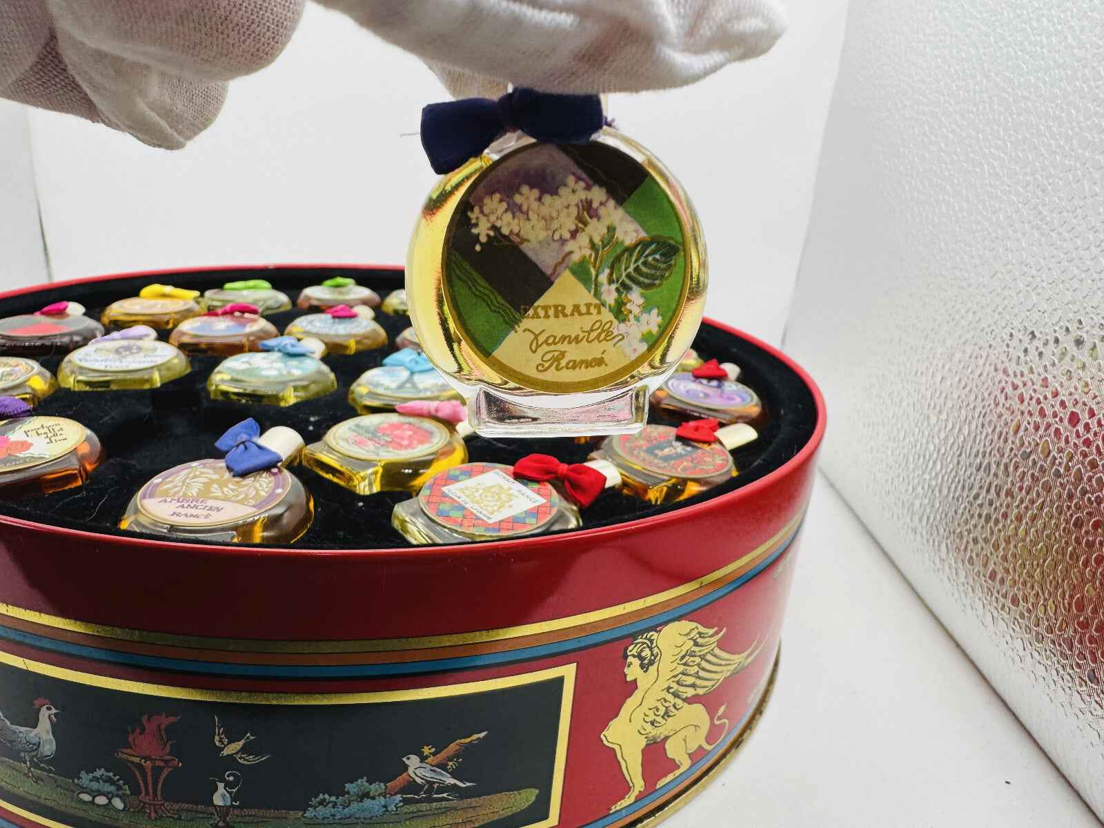 Flacone di profumo Rance con etichetta raffinata su un fondo di vaso decorato