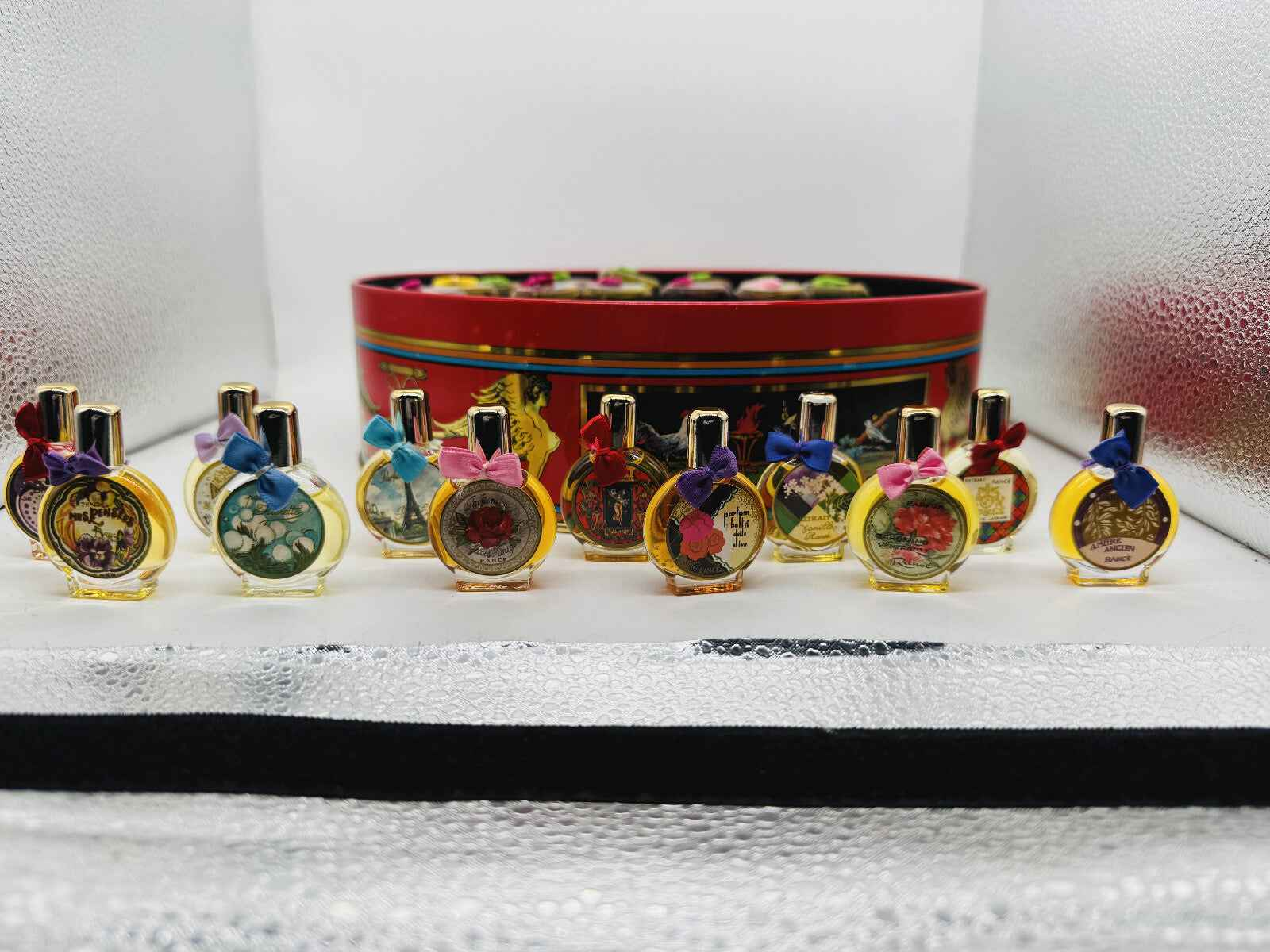 Collezione di profumi Rance in flaconi decorativi con nastri colorati su sfondo elegante