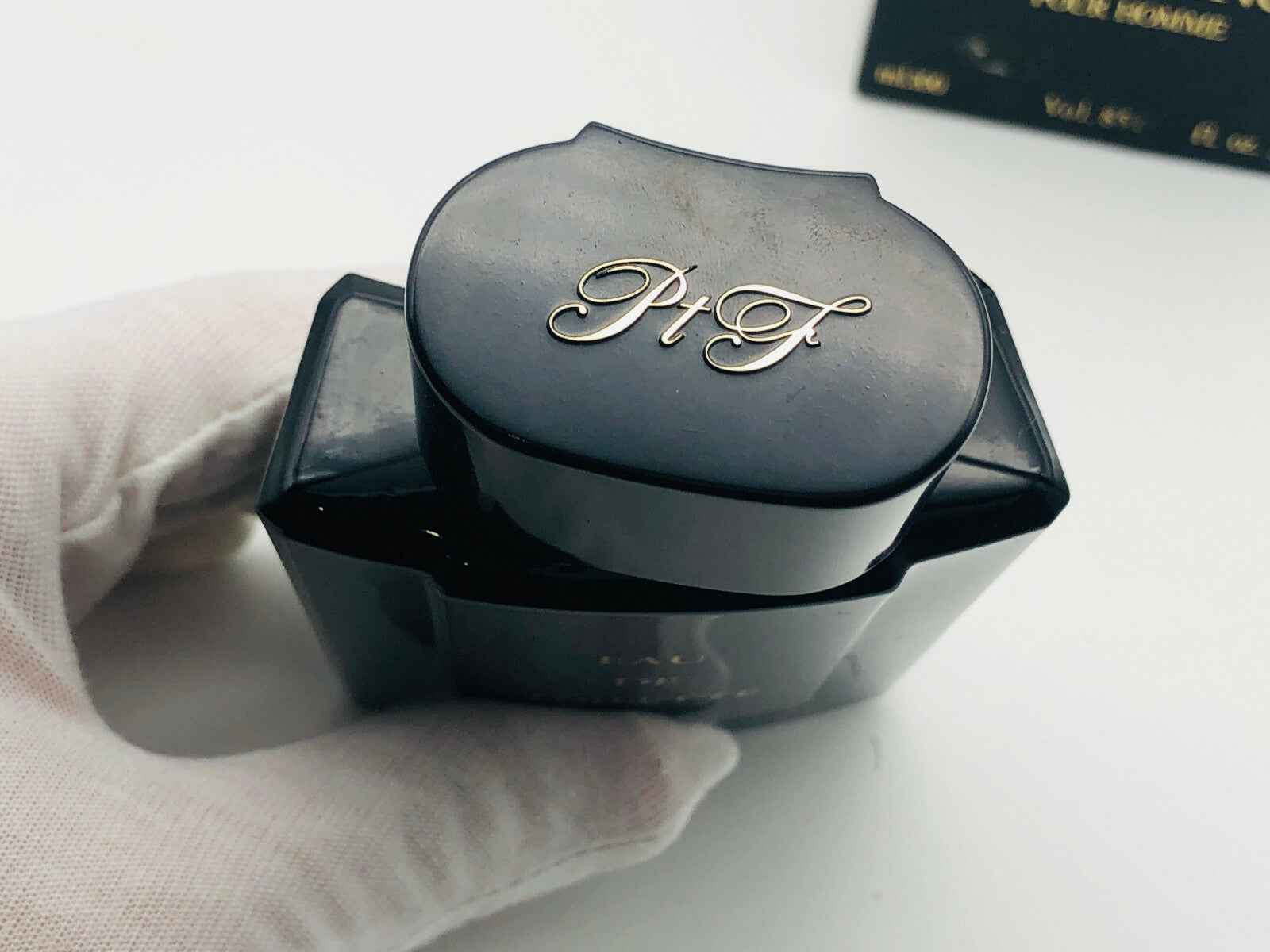 Flacone di profumo Arrogance Pour Homme in nero con tappo elegante e logo dorato