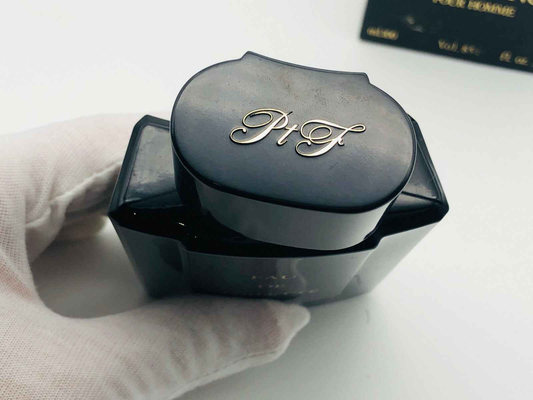 Flacone di profumo Arrogance Pour Homme in nero con tappo elegante e logo dorato