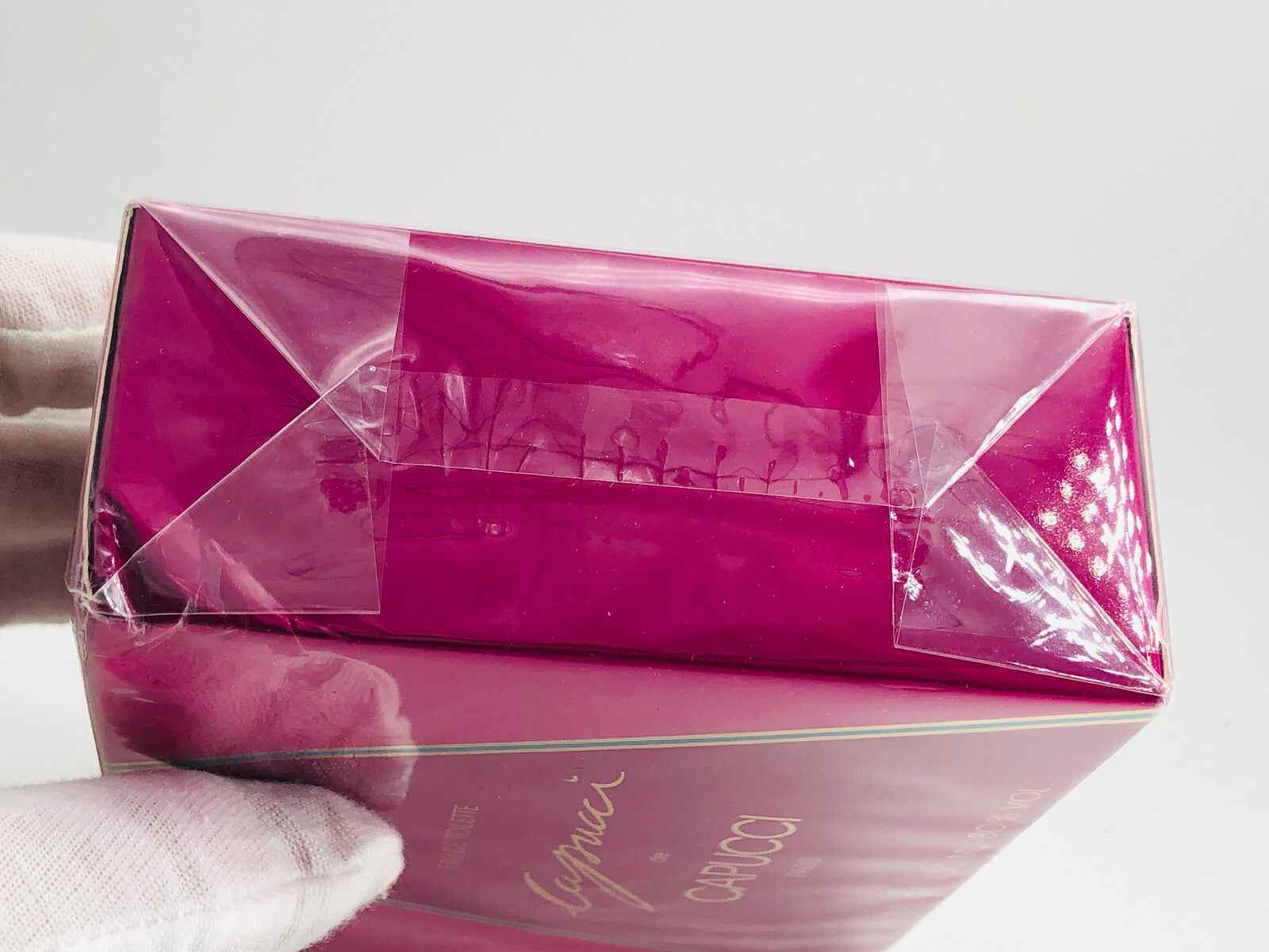 Scatola del profumo Capucci De Capucci con confezione rosa brillante e nastro trasparente