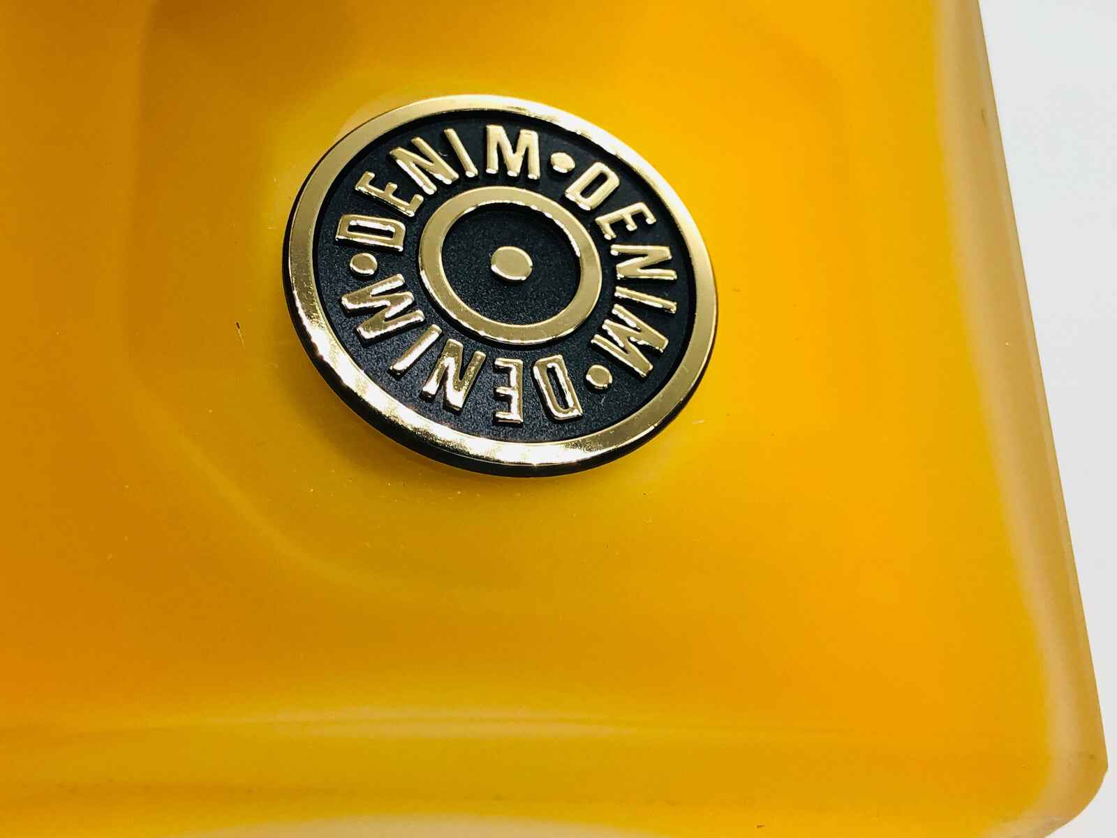 Dettaglio sul tappo del profumo Denim Original Vintage con logo emblematico in metallo