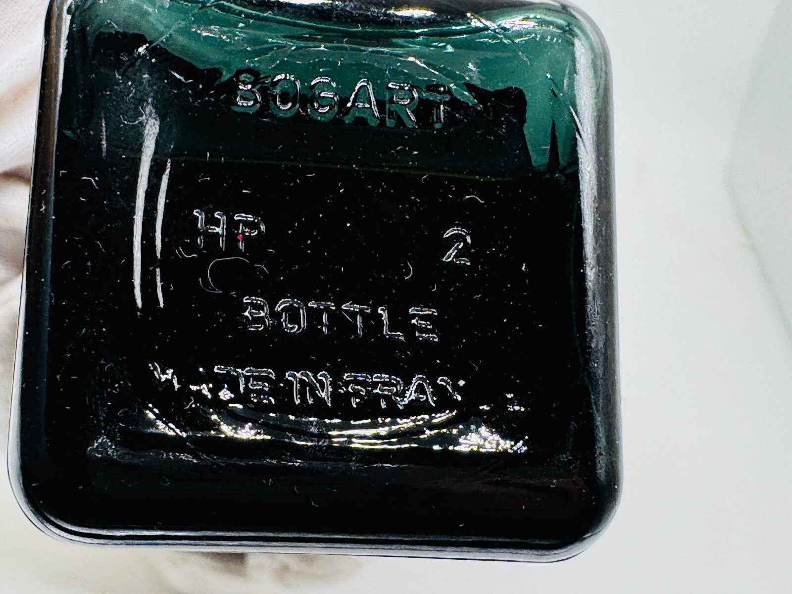 Bottiglia di profumo Jacques Bogart con design elegante e dettagli in rilievo sul fondo