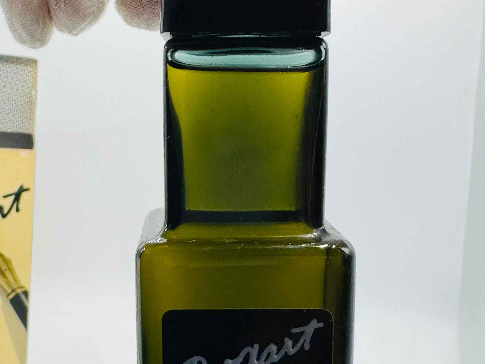 Flacone di profumo Jacques Bogart in vetro scuro con tappo nero ed etichetta elegante