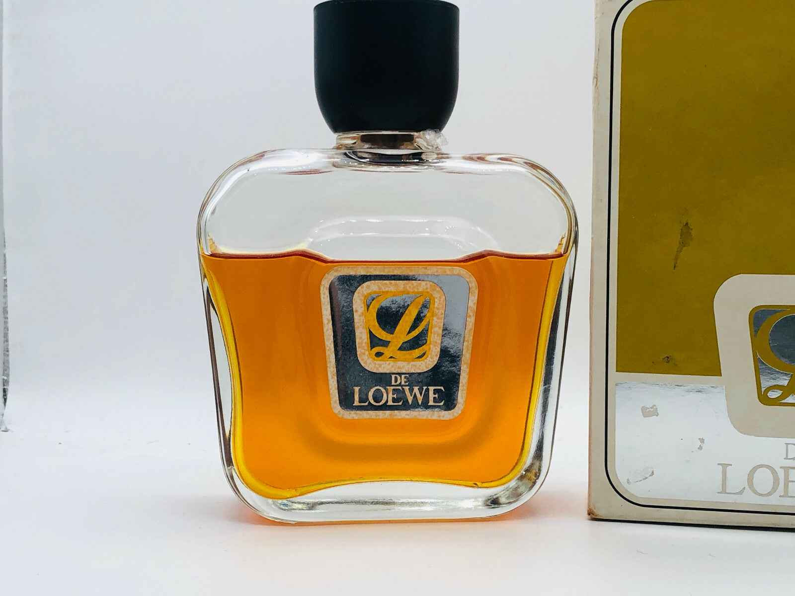 Flacone di profumo L De Loewe con design elegante e liquido ambrato
