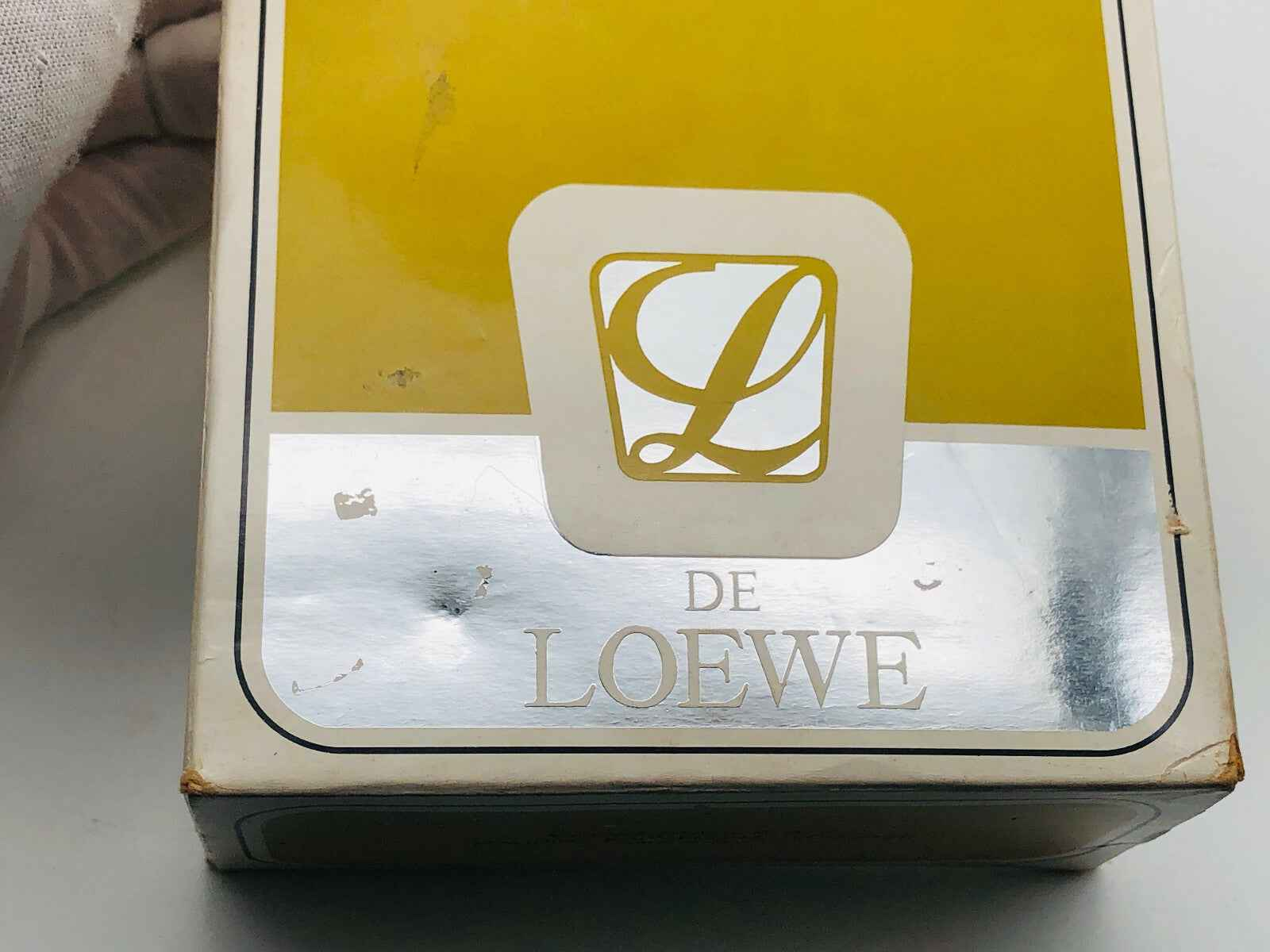Scatola vintage del profumo L De Loewe con design elegante e colori giallo e argento