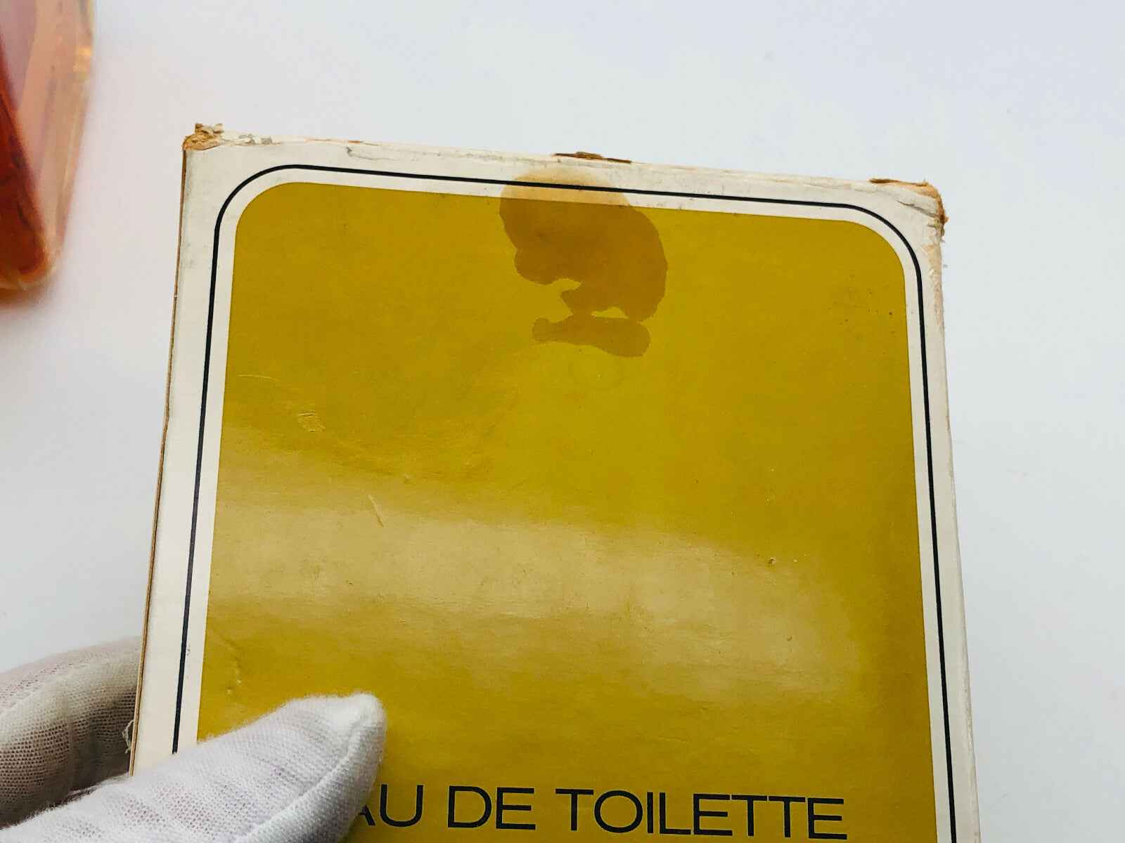 Confezione di profumo L De Loewe con etichetta visibile e macchia sul lato superiore