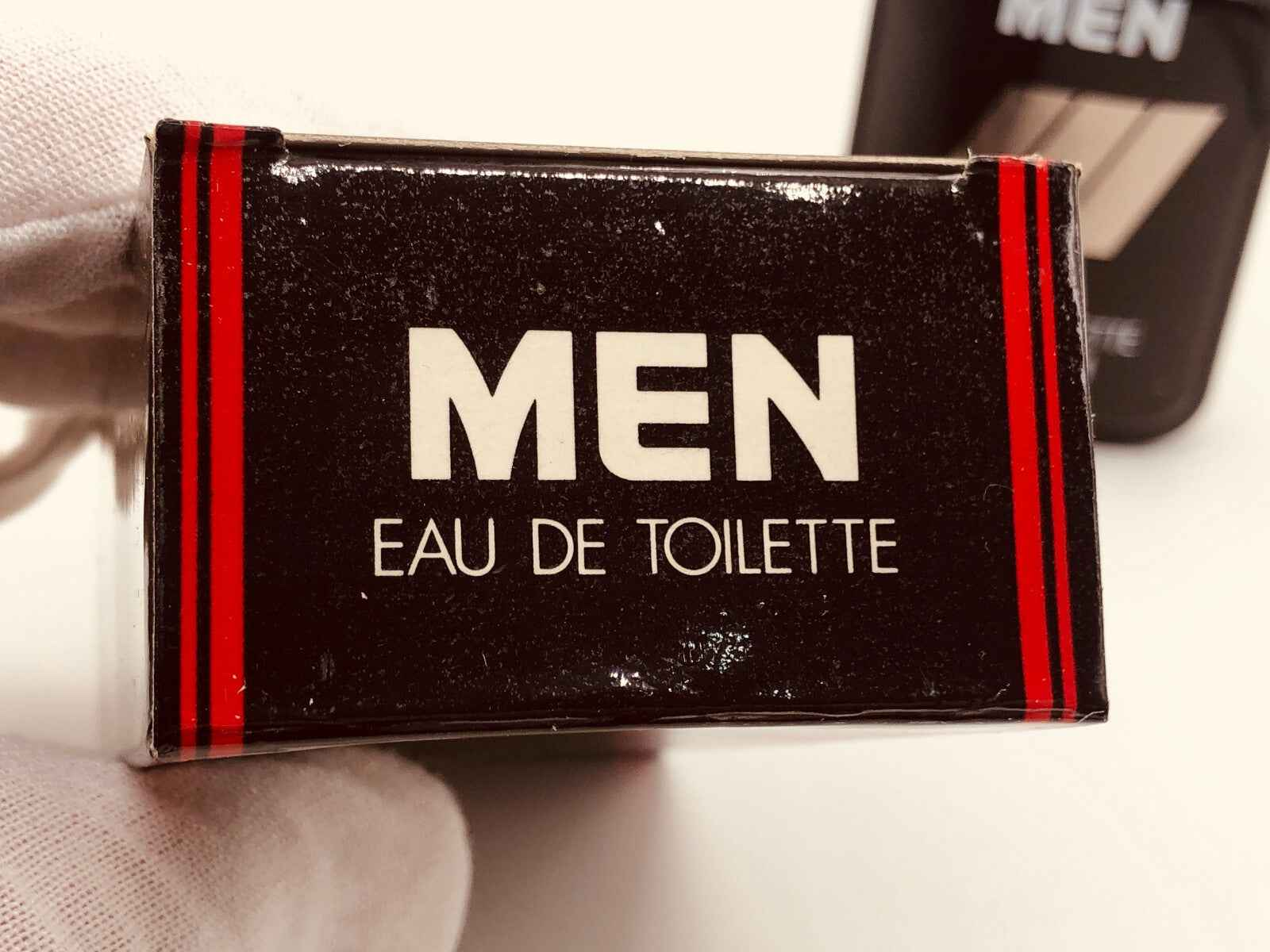 Confezione del profumo Mennen Men con scritta chiara 'Eau de Toilette' in elegante design nero