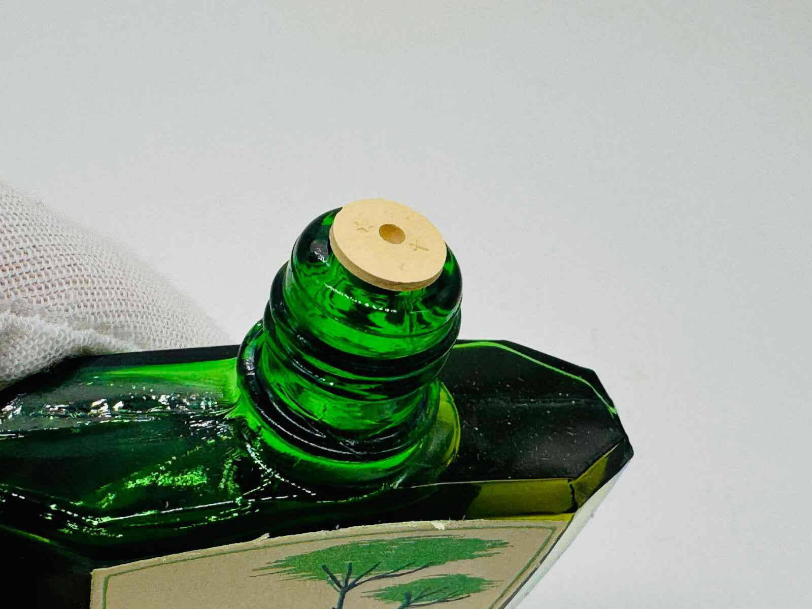 Dettaglio del flacone di profumo Pino Arbell con tappo di legno distintivo