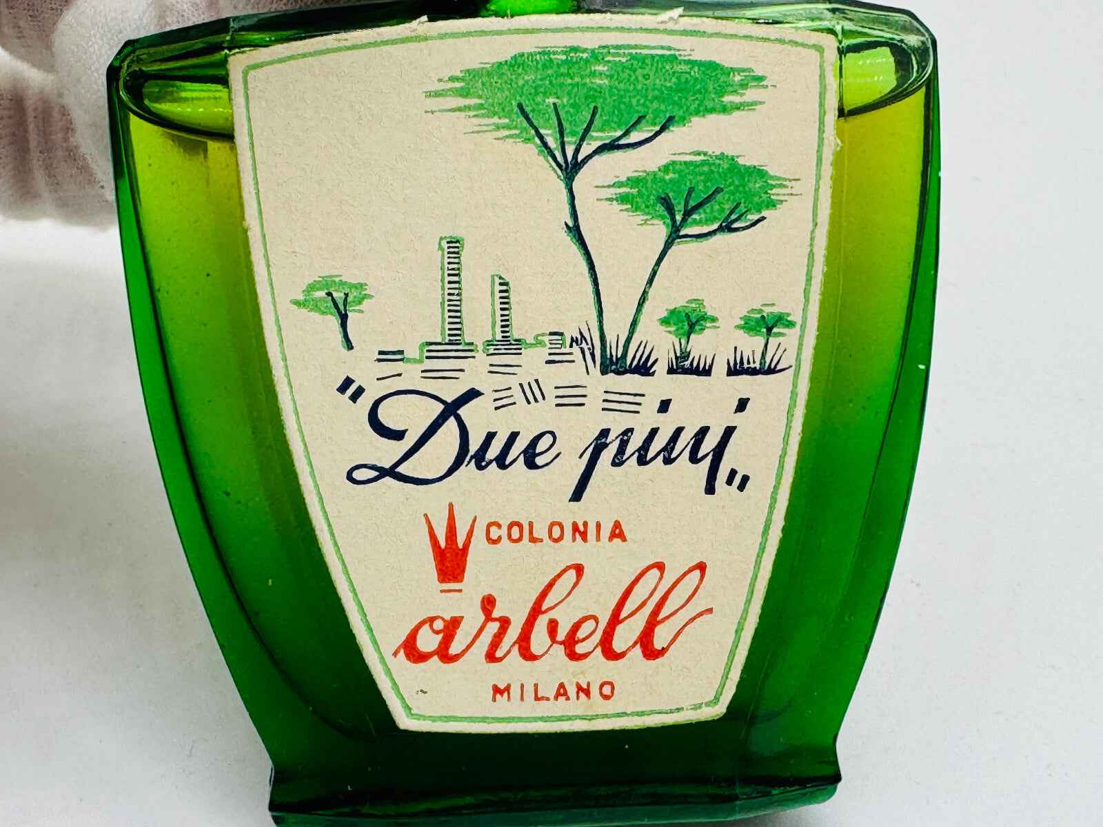 Flacone di profumo Pino Arbell in vetro verde con etichetta vintage e design elegante