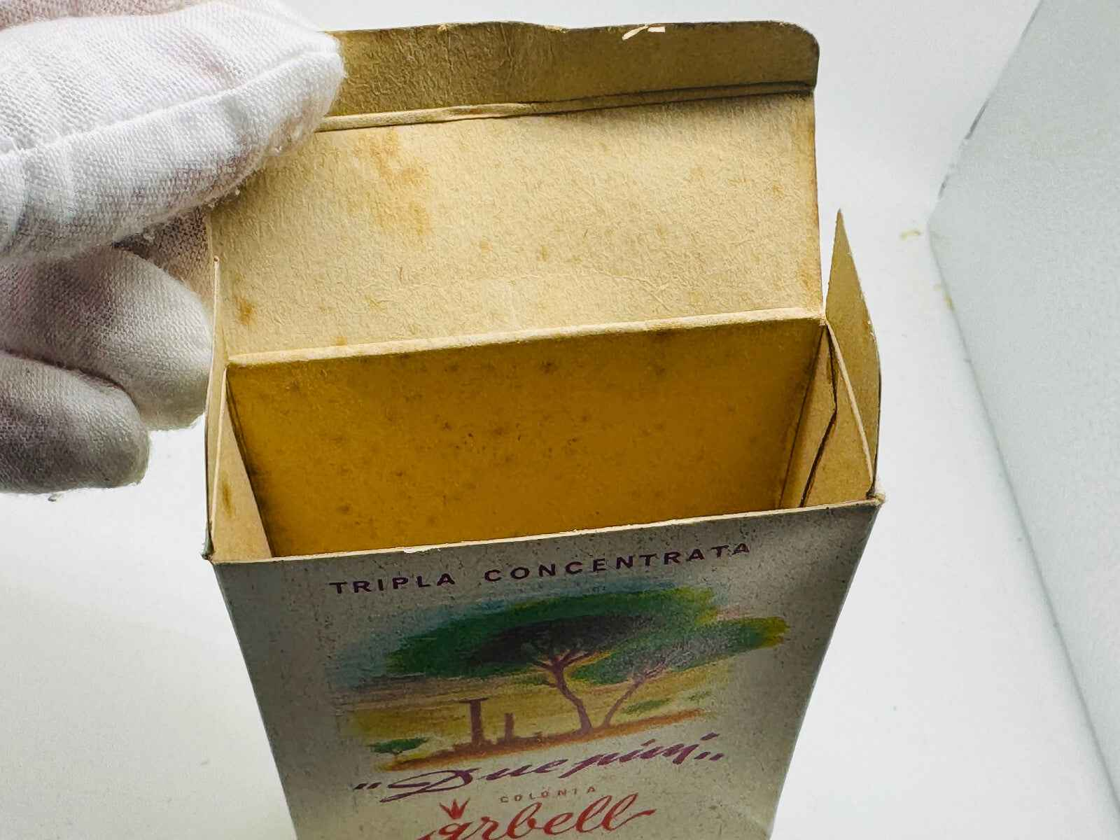 Scatola aperta di Profumo Pino Arbell con design vintage e colori vivaci