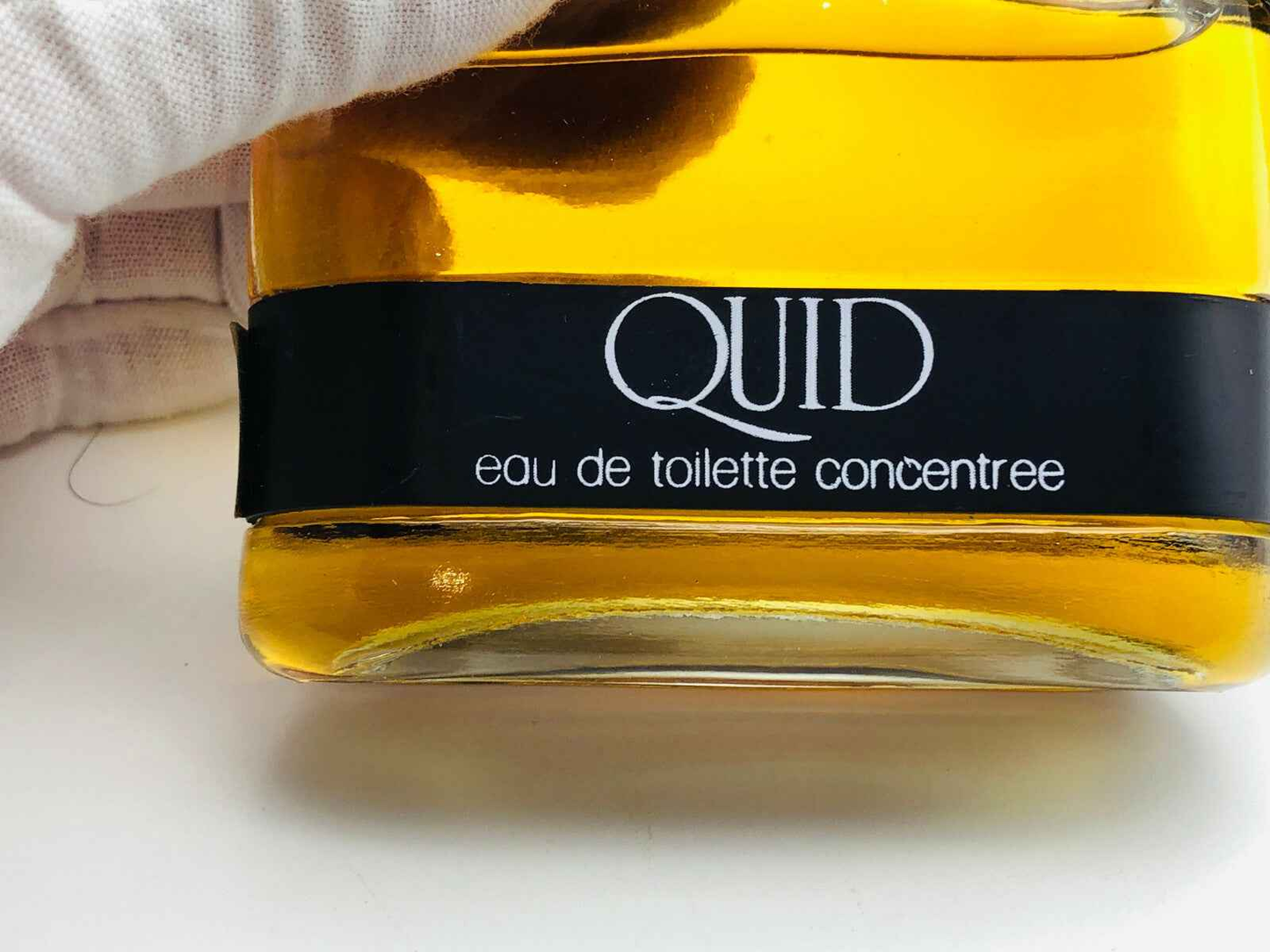 Bottiglia di profumo Quid Sojuz con etichetta nera ed elegante, e liquido giallo intenso