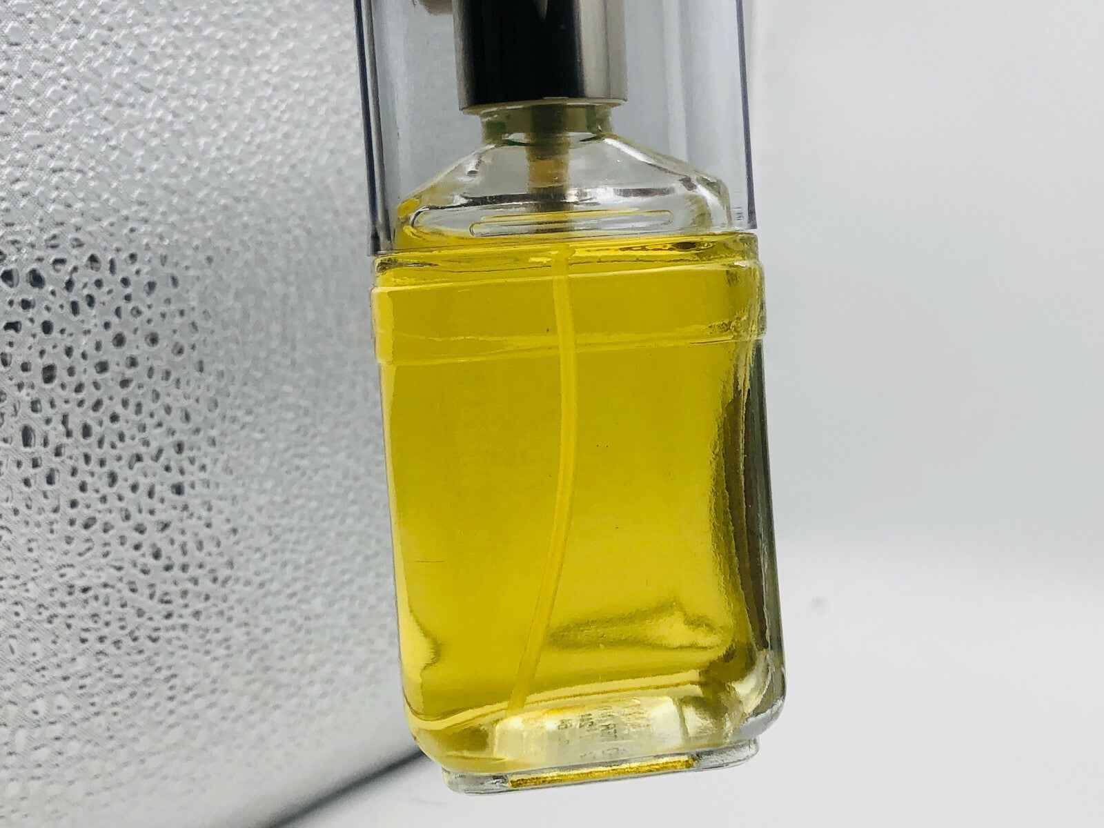 Flacone di profumo Roberta Di Camerino Vintage con liquido giallo illuminato da una luce soft