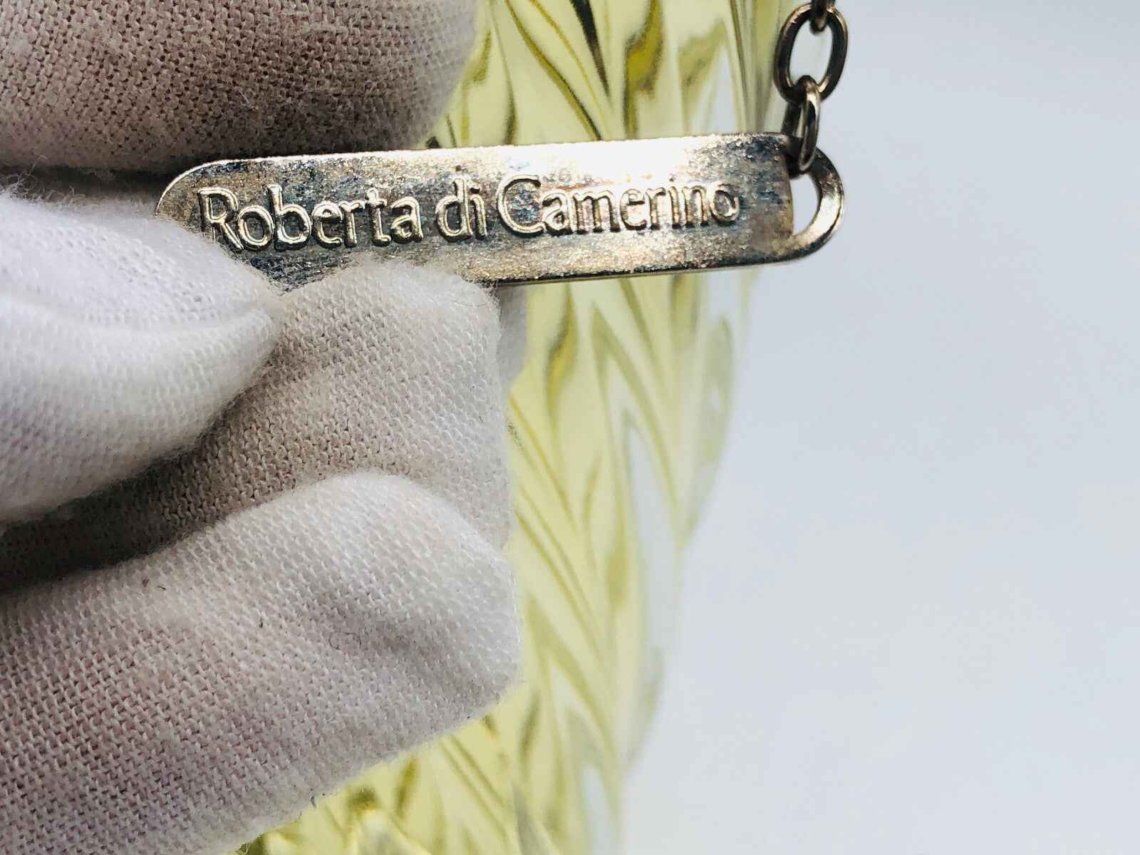 Etichetta in metallo Roberta di Camerino su borsa vintage per collezionisti di moda